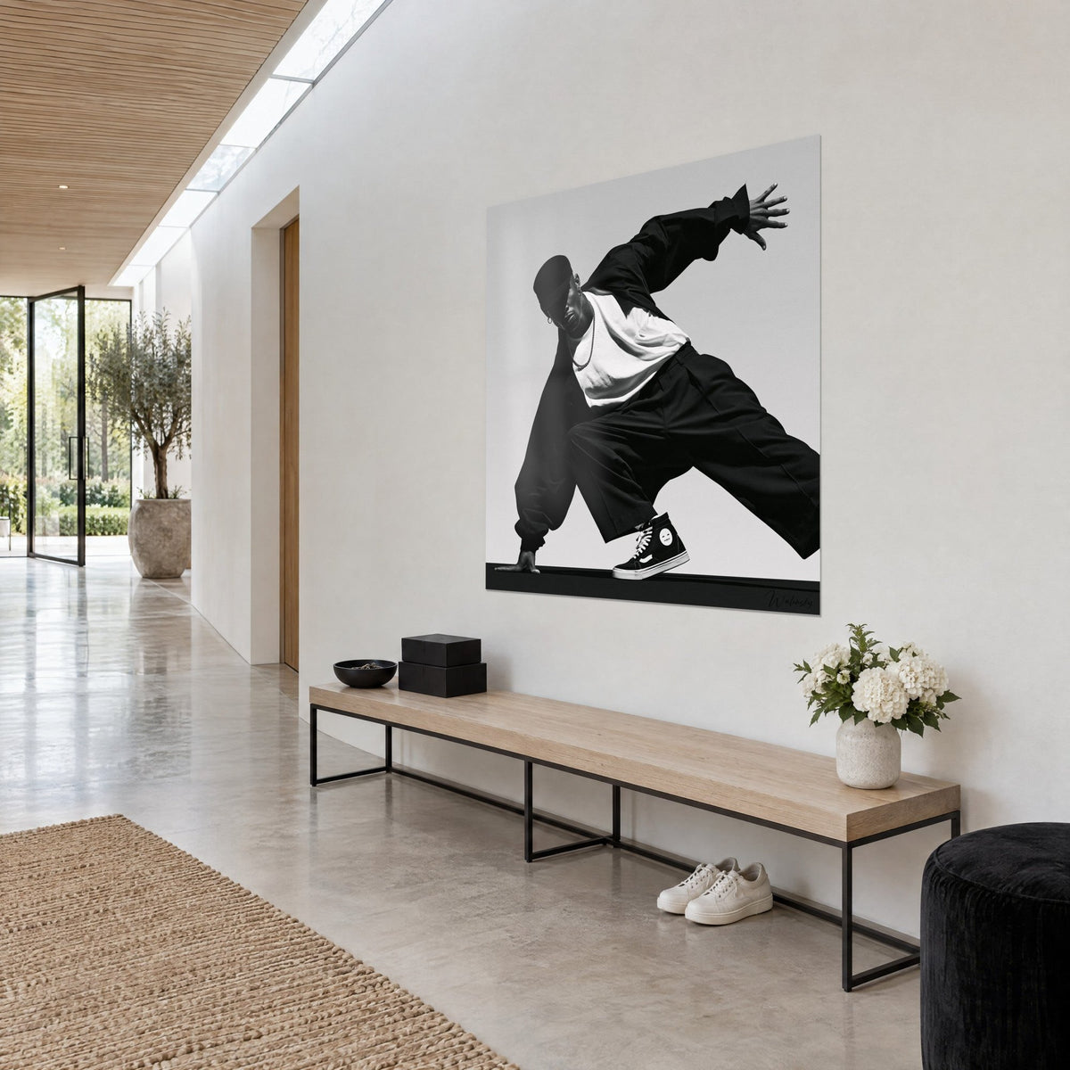 Tableau breakeur penché en avant, bras tendu, collier argenté et baskets montantes noires, mur blanc et banc en bois, vue de trois-quarts