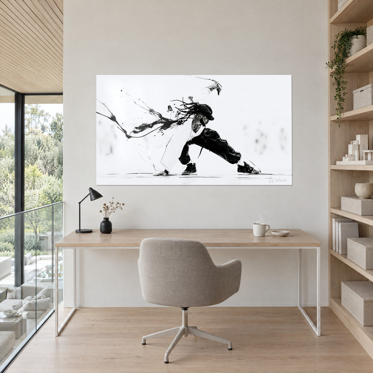 Wall art of a bent-over street dancer, play of white and black with ink drips, hanging above a light oak desk between a shelf and a floor-to-ceiling window