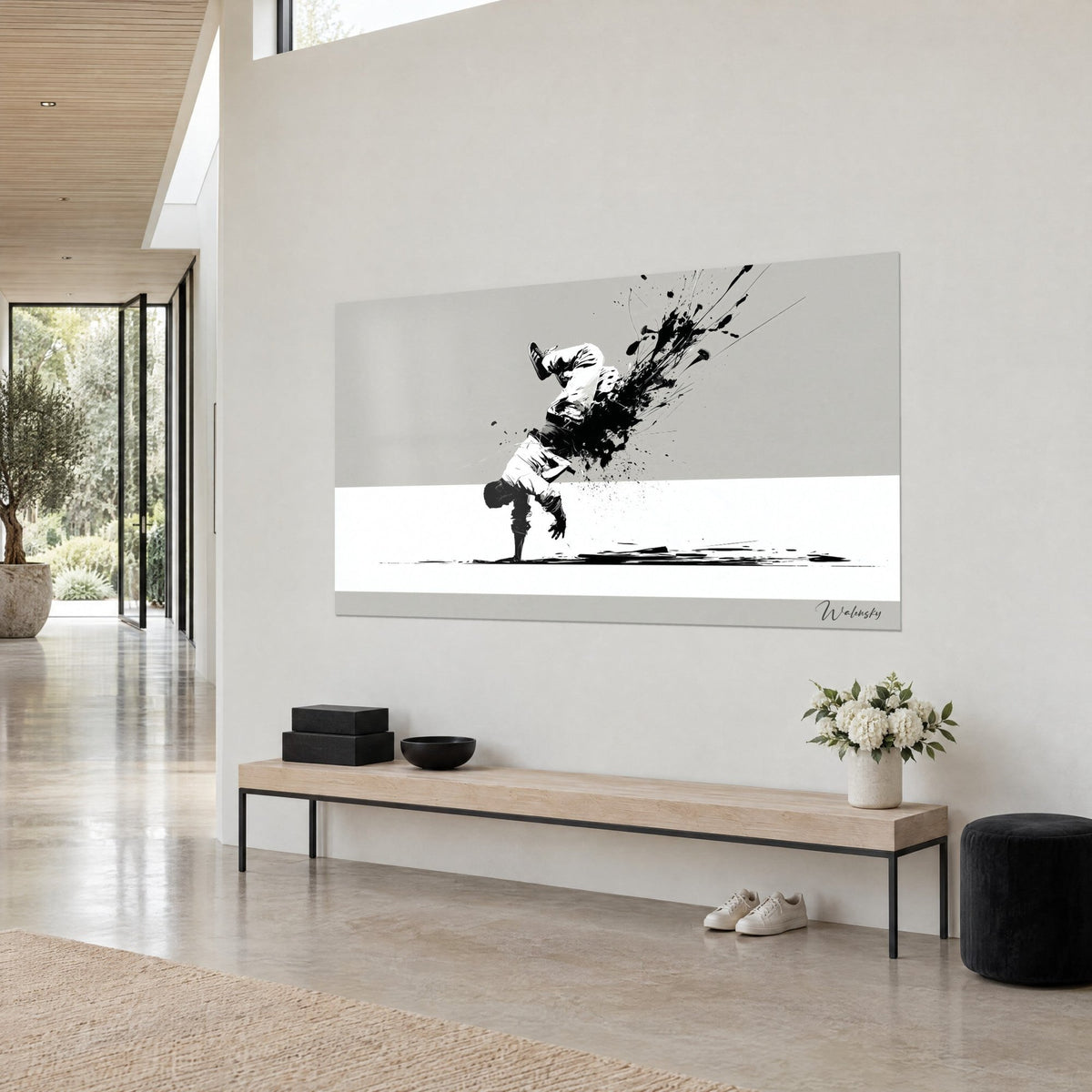 Quadro di un acrobata a testa in giù, gambe bianche e getto di inchiostro nero su grigio chiaro, sopra una panca in legno chiaro