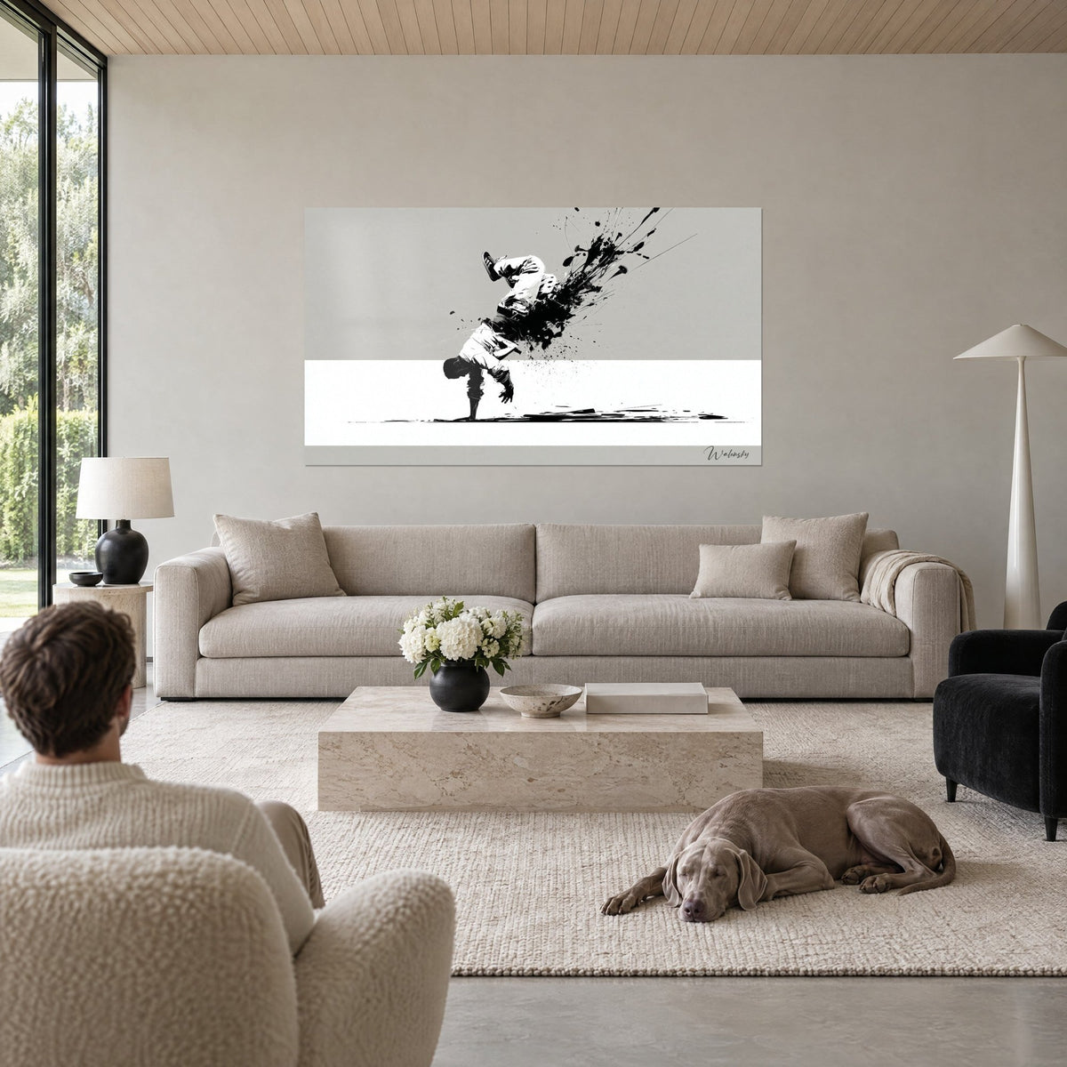 Quadro di un breakdancer in equilibrio su una mano, schizzi di inchiostro nero su sfondo grigio perla, sopra un divano in un soggiorno luminoso