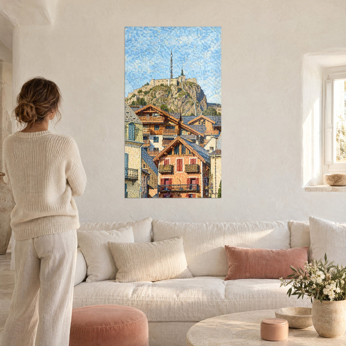Quadro fortezza di Briançon sul suo sperone roccioso, cielo azzurro punteggiato e chalet ocra e terracotta, sopra un divano in un soggiorno luminoso