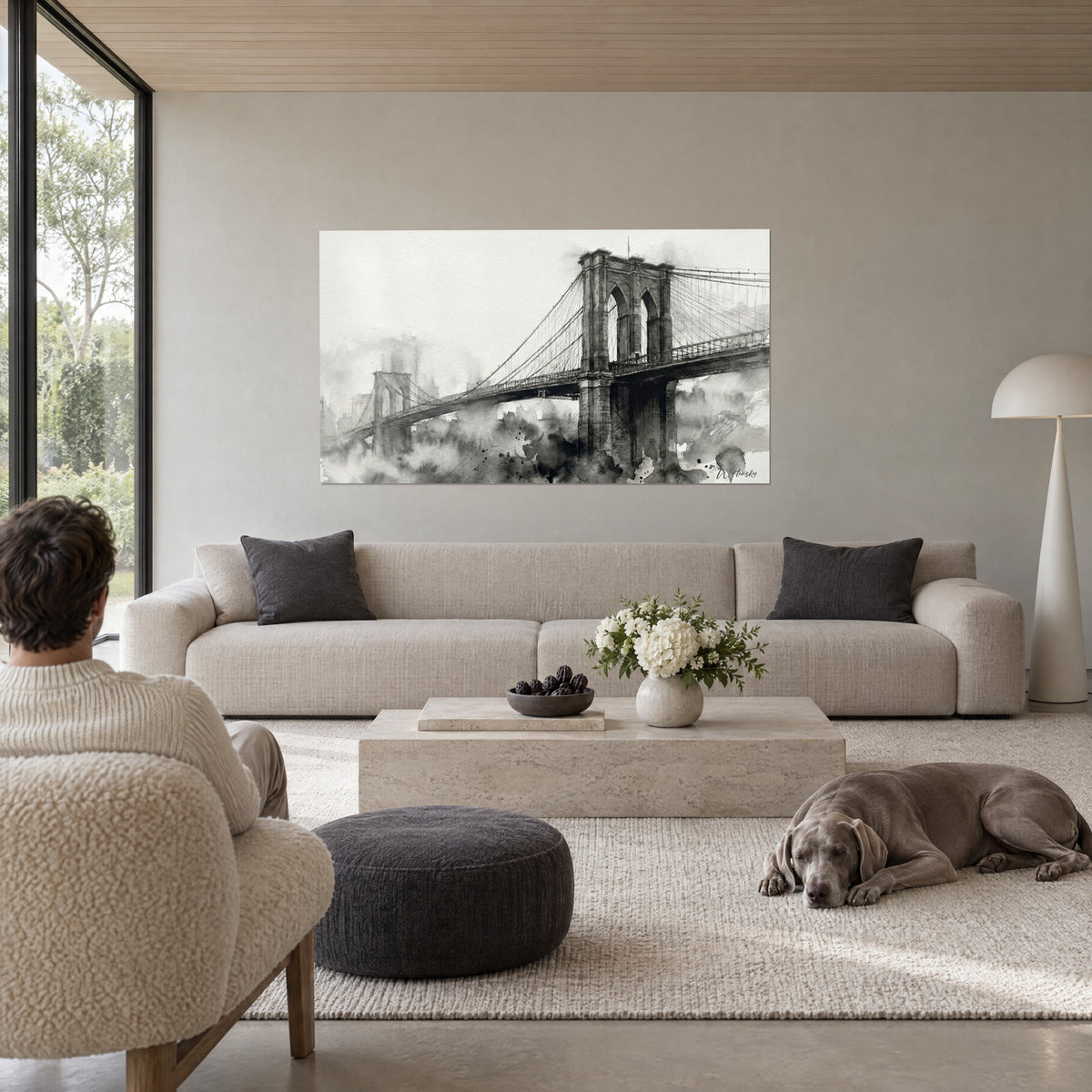 Schilderij hangbrug in zwart en grijs inktlavis, gotische toren en kabels in de mist, persoon van achteren, boven een bank in een lichte woonkamer