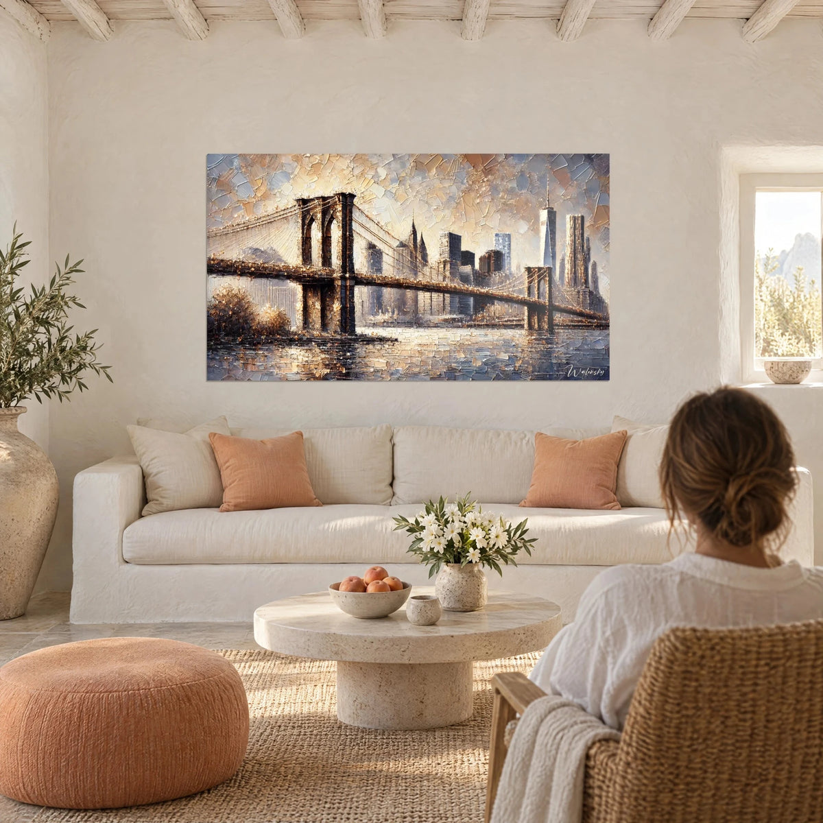 Cuadro puente de Brooklyn en ocre y azul acero, pinceladas gruesas con espátula, una mujer de espaldas, sobre un sofá en un salón luminoso