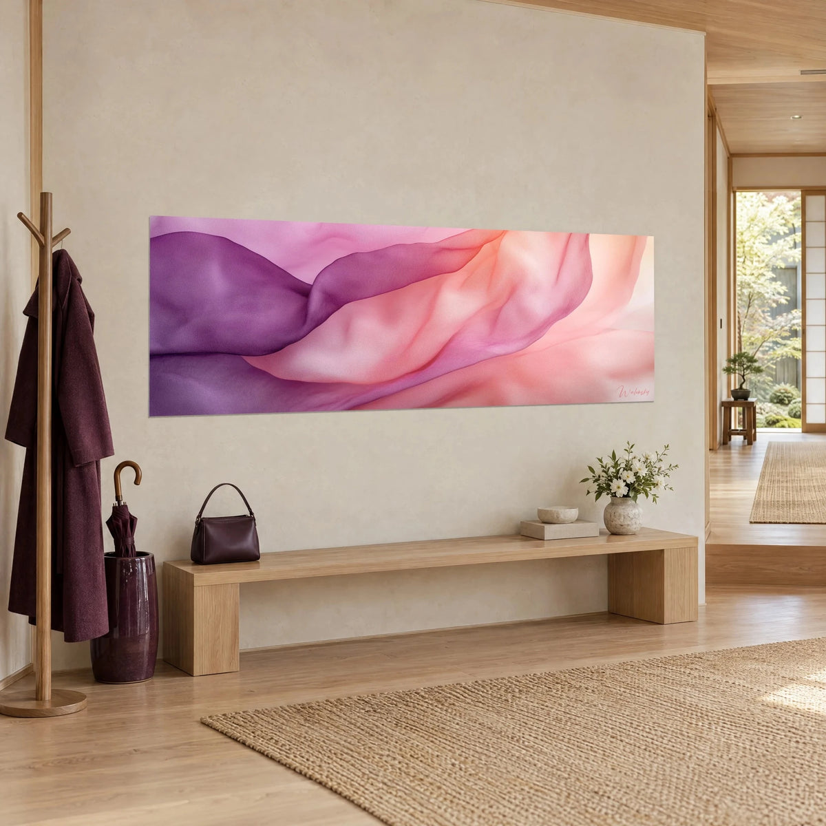 Quadro di mussola drappeggiata magenta e pesca con morbide ondulazioni, appeso al muro sopra una panca in legno chiaro