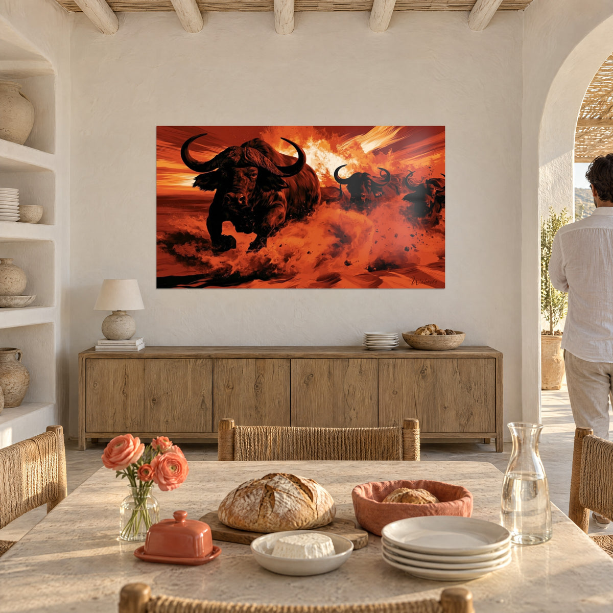 Wall art charge of dark buffalo kicking up red and orange clods of earth, in a sunny dining room
