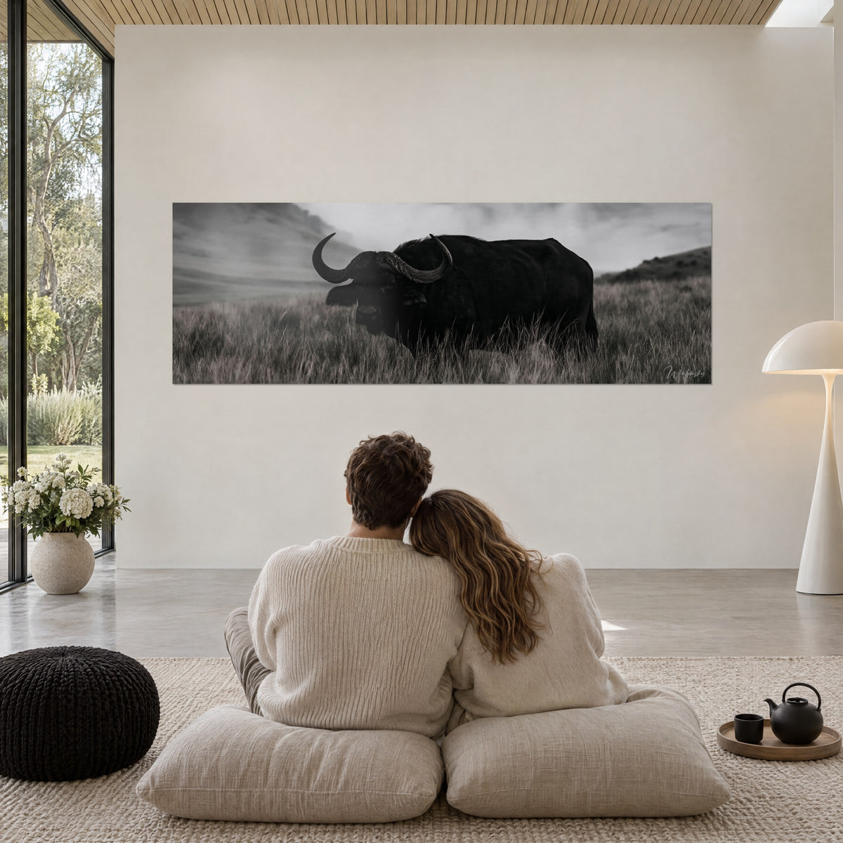 Schilderij groot panorama van een donkere buffel met gebogen hoorns, droog grijs gras en mistige lucht, koppel van achteren op kussens