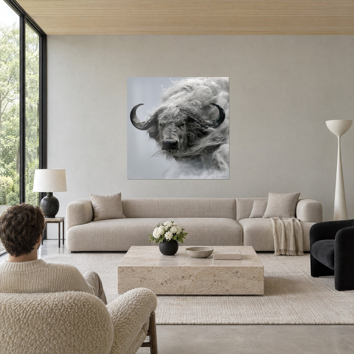 Tableau buffle gris aux cornes recourbées noires, crinière de brume argentée, au-dessus d'un canapé dans un salon lumineux