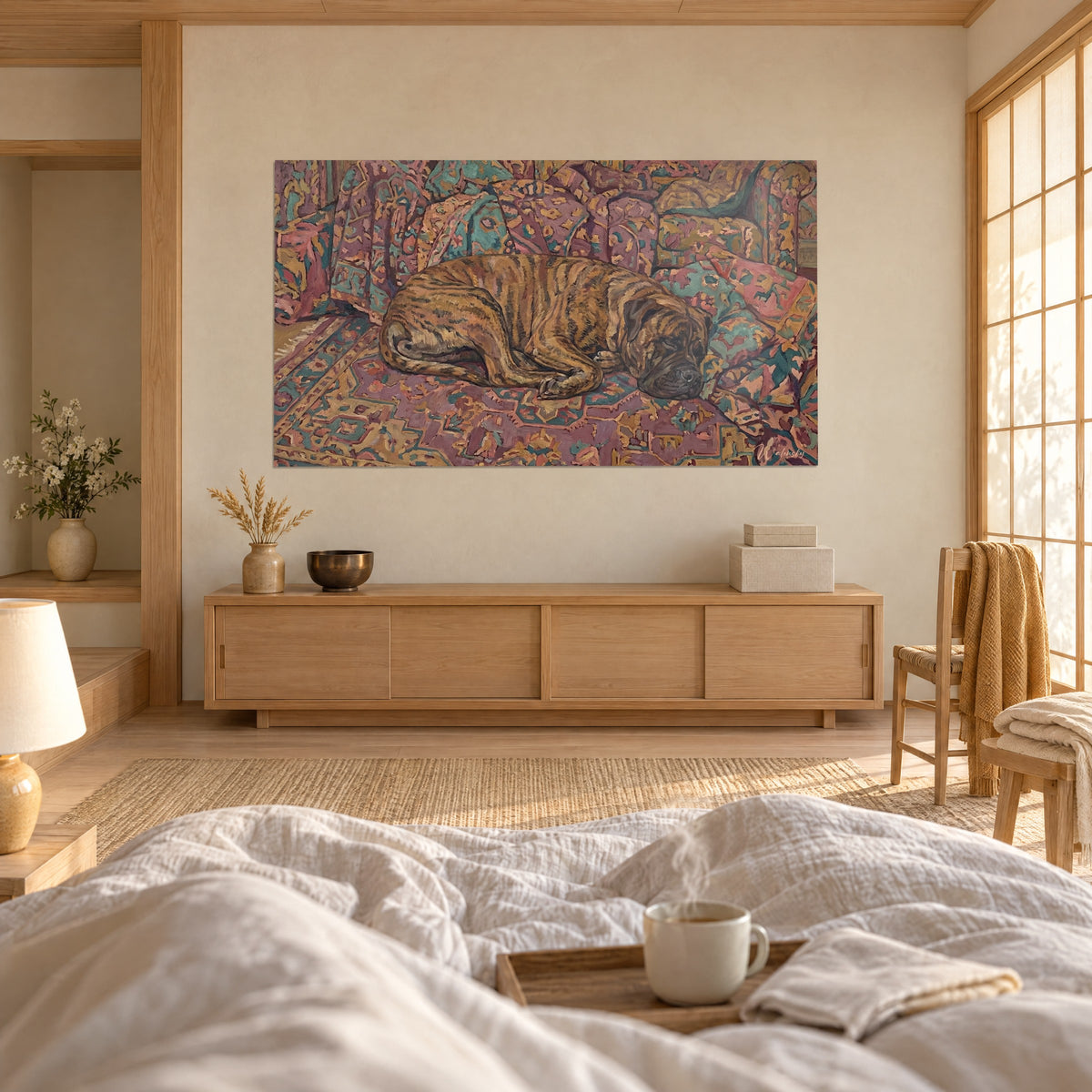 Cuadro mastín atigrado adormilado en un motivo oriental rosa, verde agua y ocre, encima de una cama en un dormitorio luminoso