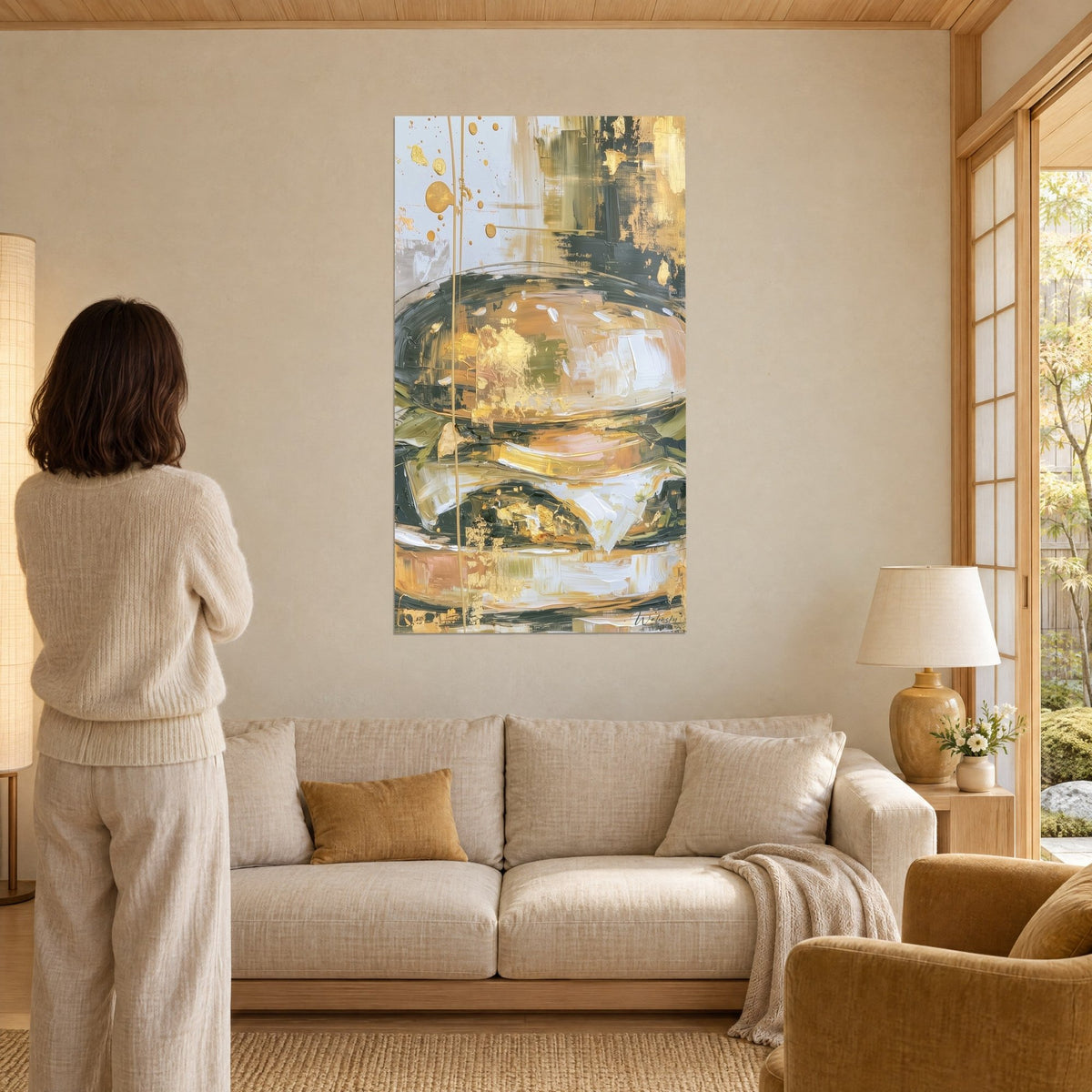Wall art abstract hamburger in gold and olive green paste, pearl grey background, above a sofa in a bright living room