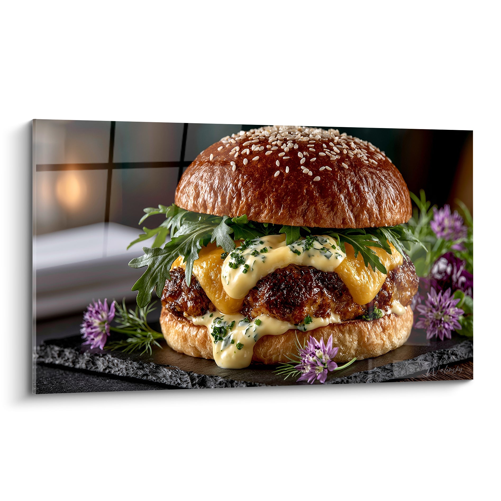 Burger doré au fromage fondu et sauce crémeuse, entouré de fleurs mauves sur ardoise anthracite