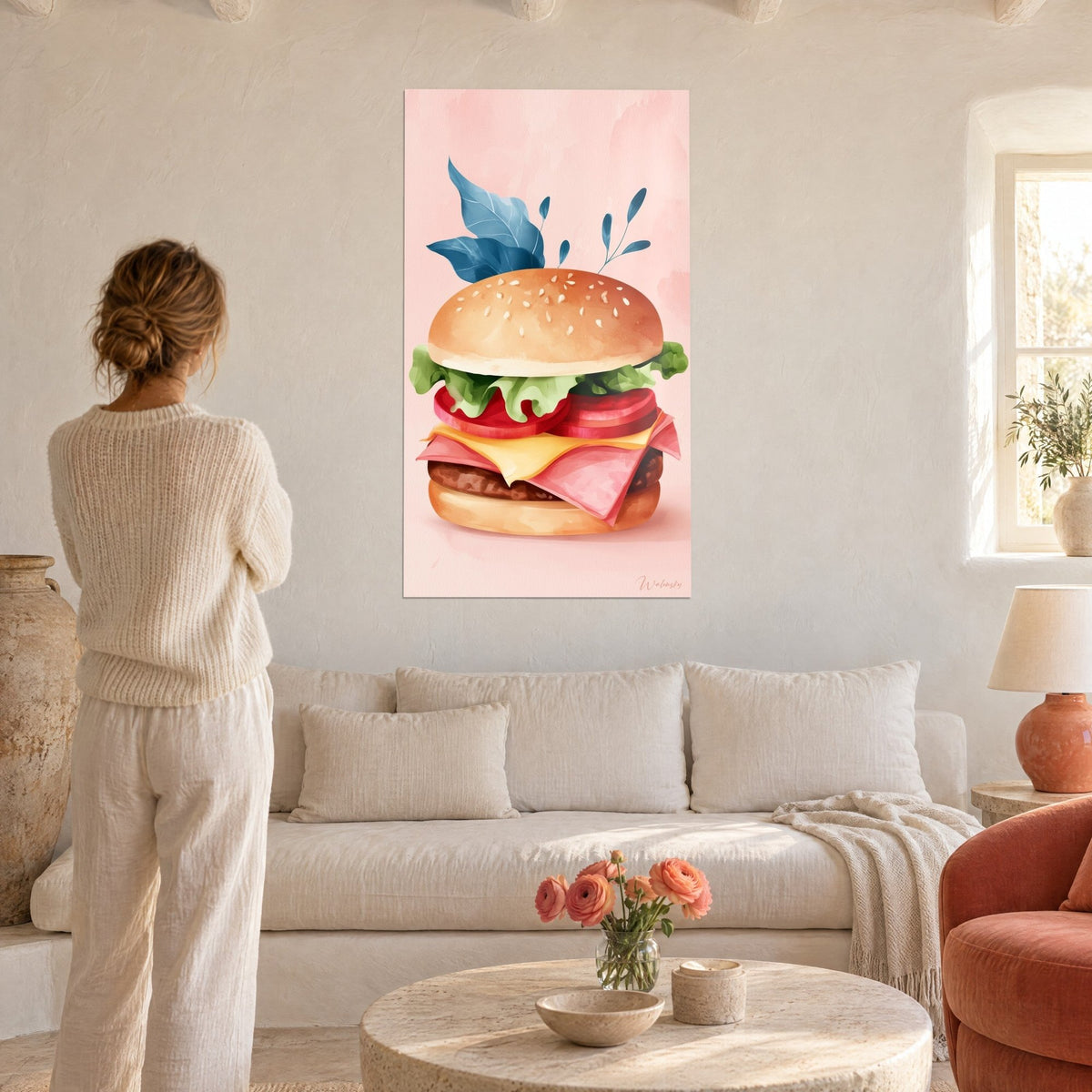 Gemälde Cheeseburger mit rosa Schinkenscheiben und petrolblauen Blättern, Frau von hinten, über einem Sofa in einem hellen Wohnzimmer