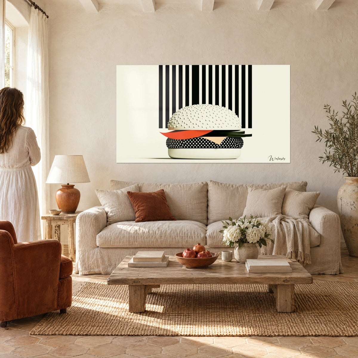 Quadro hamburger grafico con panino crema con semi e lamella arancio su strisce nere, sopra un divano in un soggiorno luminoso