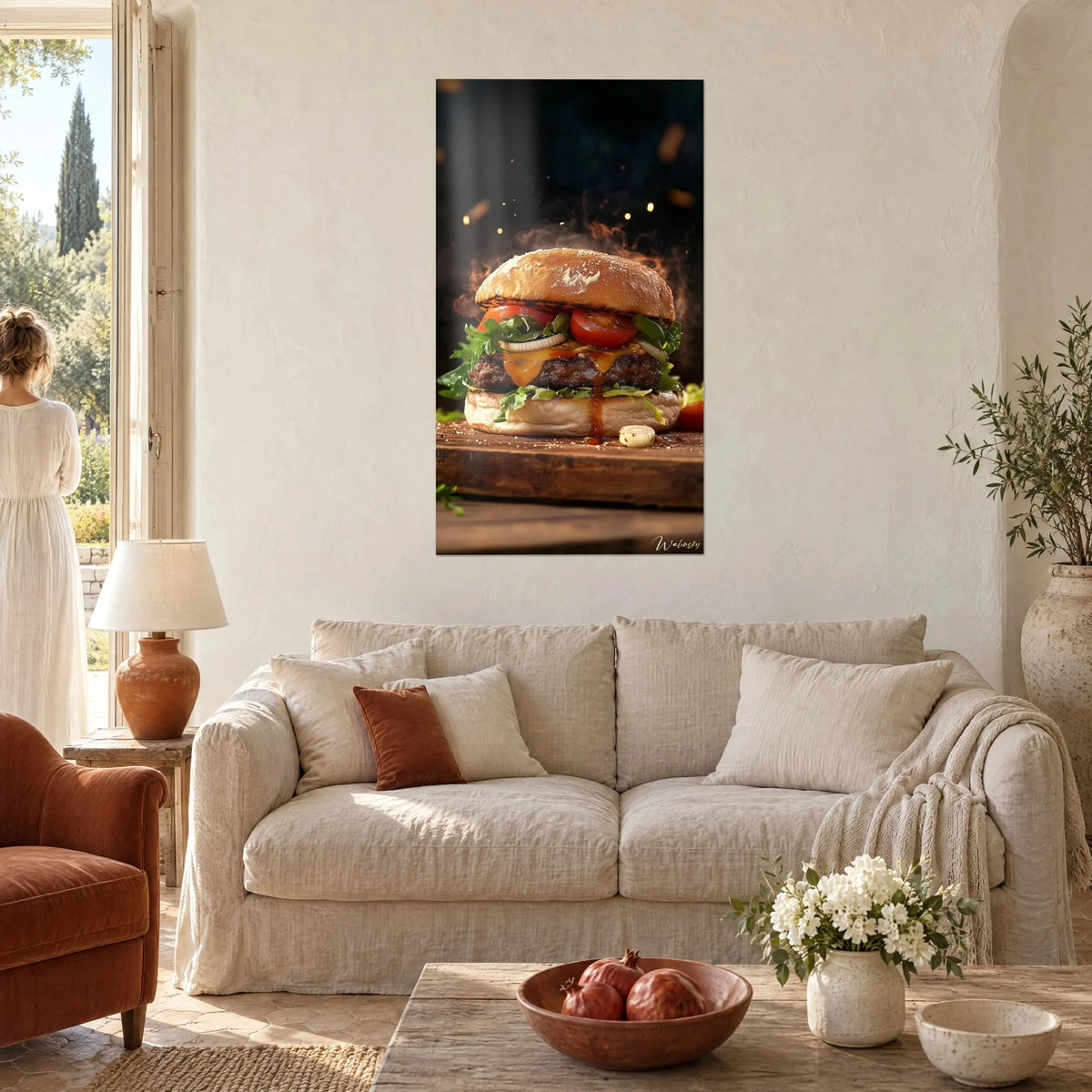 Cuadro hamburguesa gourmet, pan dorado y tomate rojo sobre una tabla de madera, una mujer de espaldas sobre un sofá en un salón luminoso