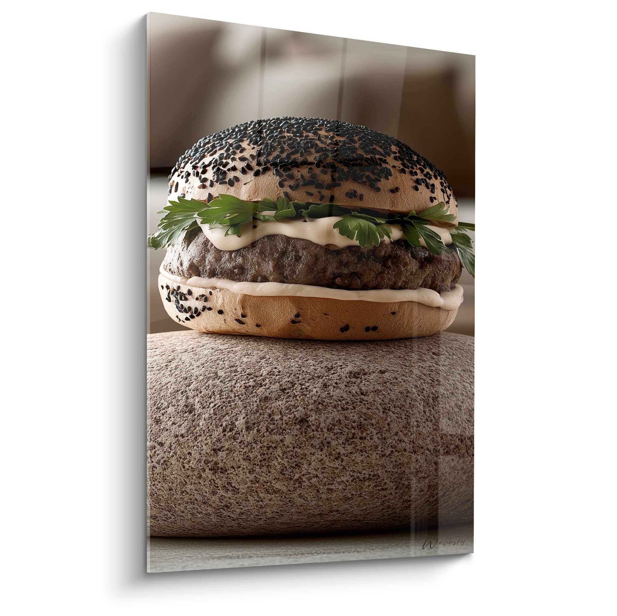 Burger au pain noir sesame posé sur une pierre grise, viande brune et sauce blanche apparentes