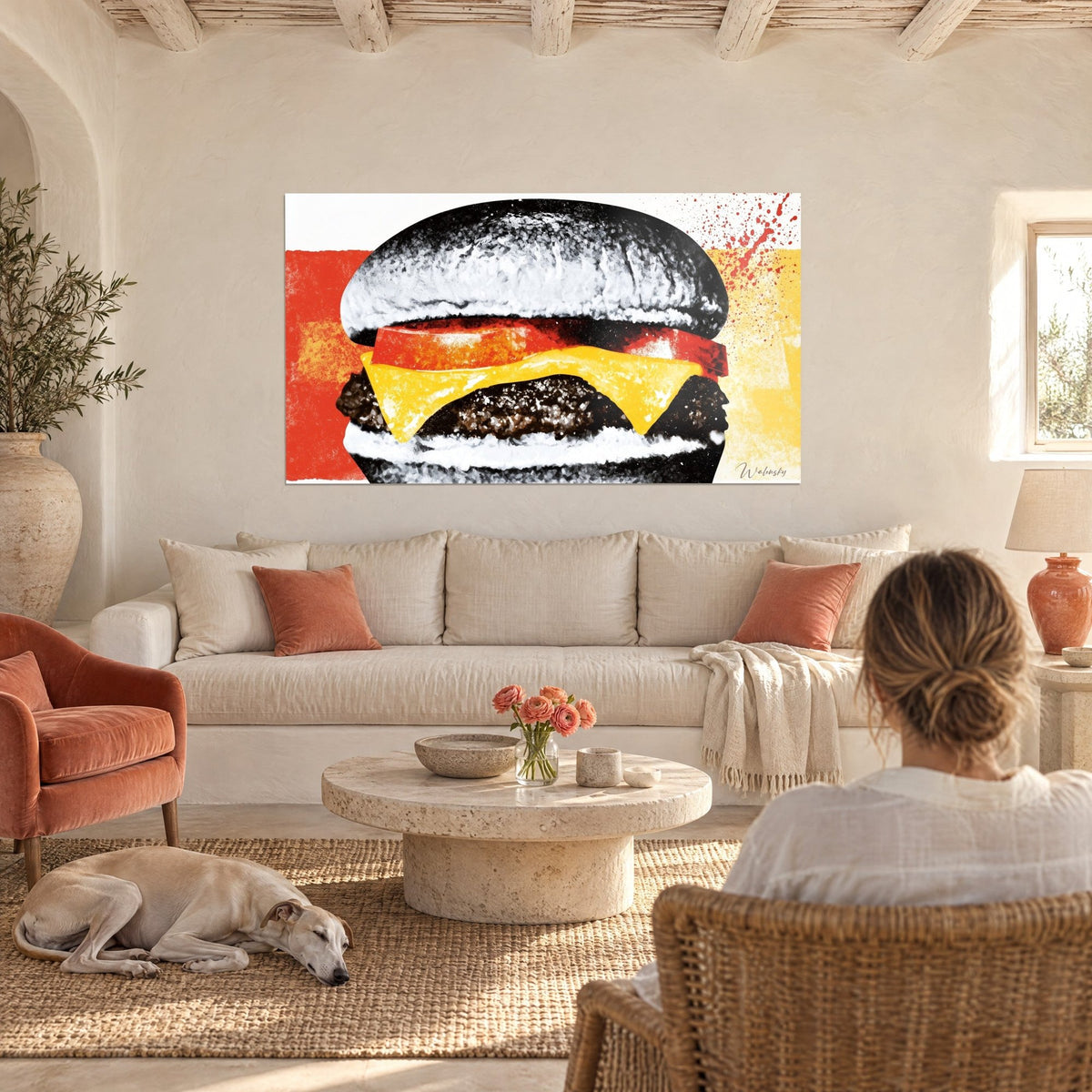 Cuadro de cheeseburger con pan negro escarchado, cheddar amarillo y tomate rojo, una mujer de espaldas y un galgo, sobre un sofá en un salón luminoso