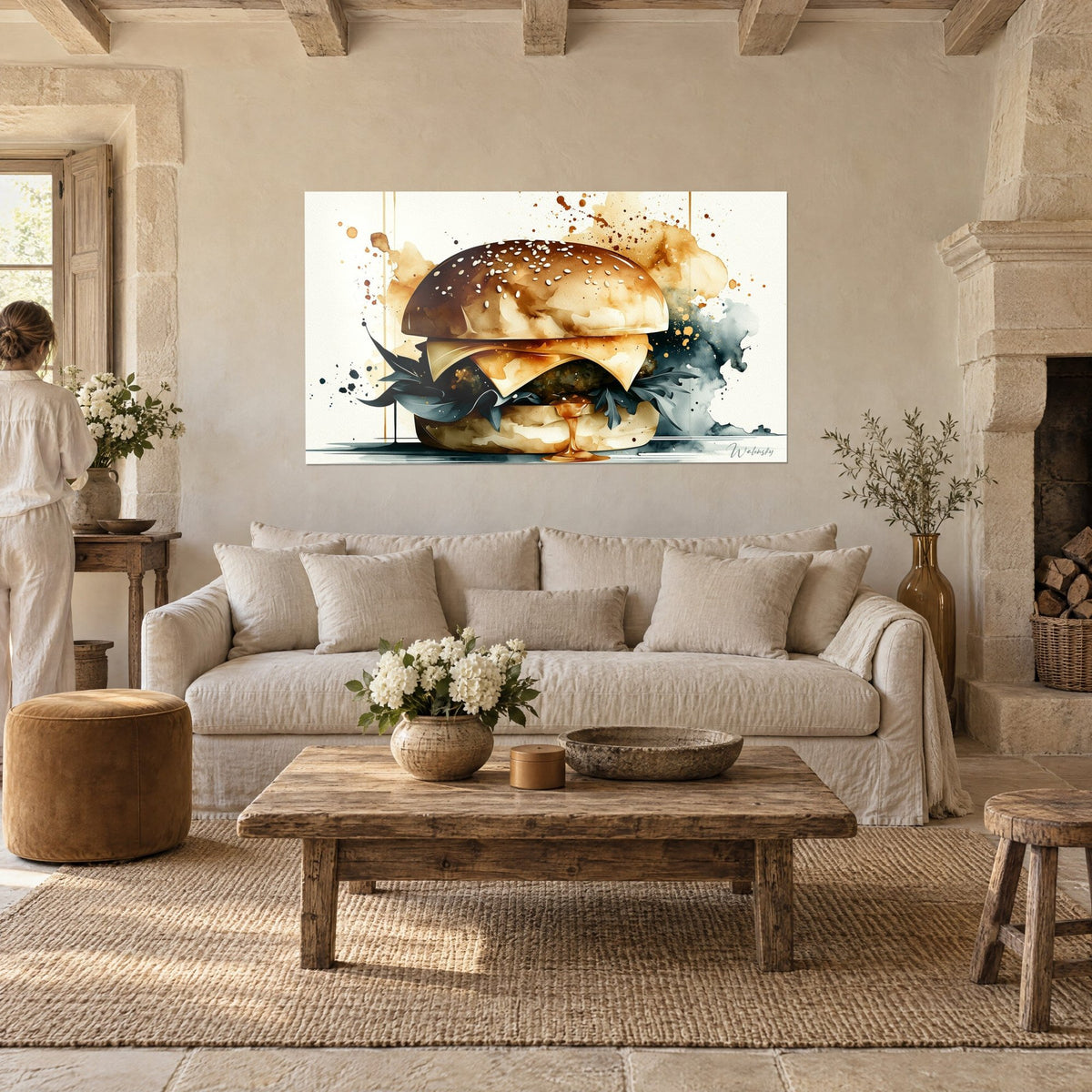 Quadro hamburger con panino dorato cosparso di sesamo, foglie blu ardesia, con una donna di spalle, sopra un divano in un soggiorno luminoso