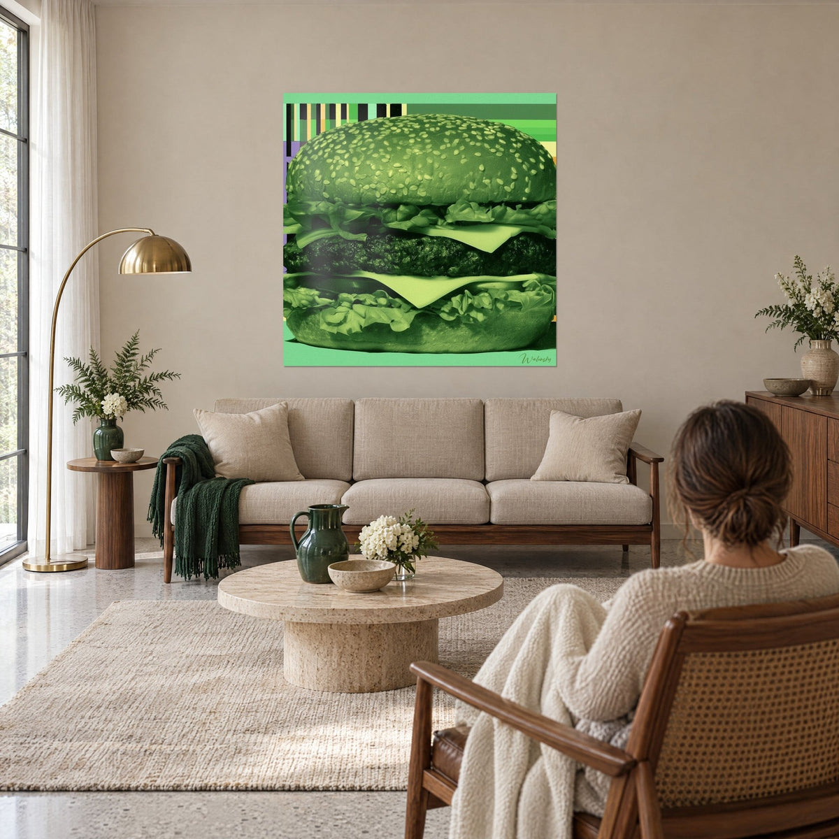 Quadro con un enorme hamburger in verde monocromo, panino al sesamo e formaggio verde pallido, sopra un divano in un soggiorno luminoso