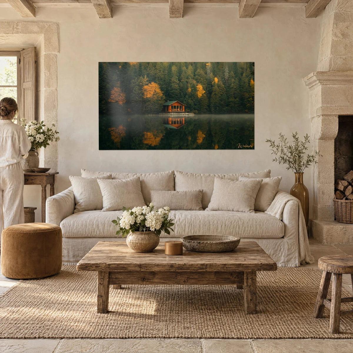 Wall art copper-toned wooden cabin on a lakeside, dark green forest and golden larches, above a sofa in a bright living room