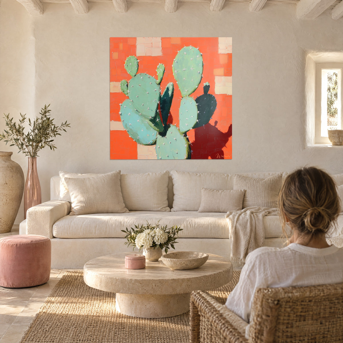 Tableau cactus raquette vert d'eau aux épines blanches sur fond corail, ombre brun-rouge, au-dessus d'un canapé dans un salon lumineux