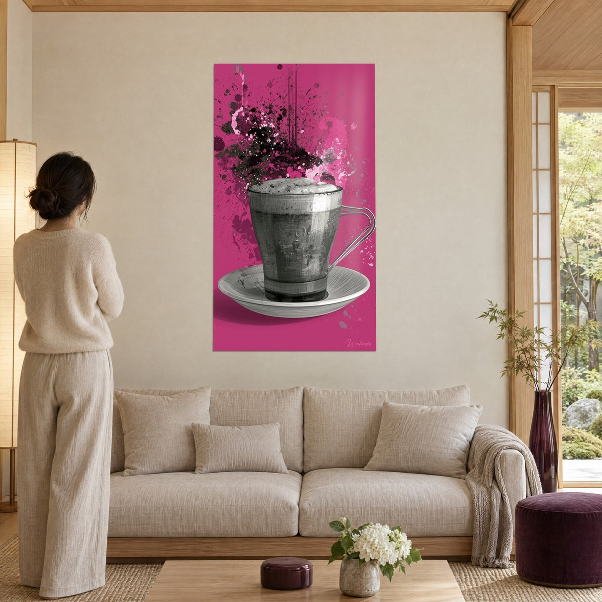 Cuadro taza de café gris espumoso sobre fondo fucsia, salpicaduras negras, encima de un sofá en un salón luminoso