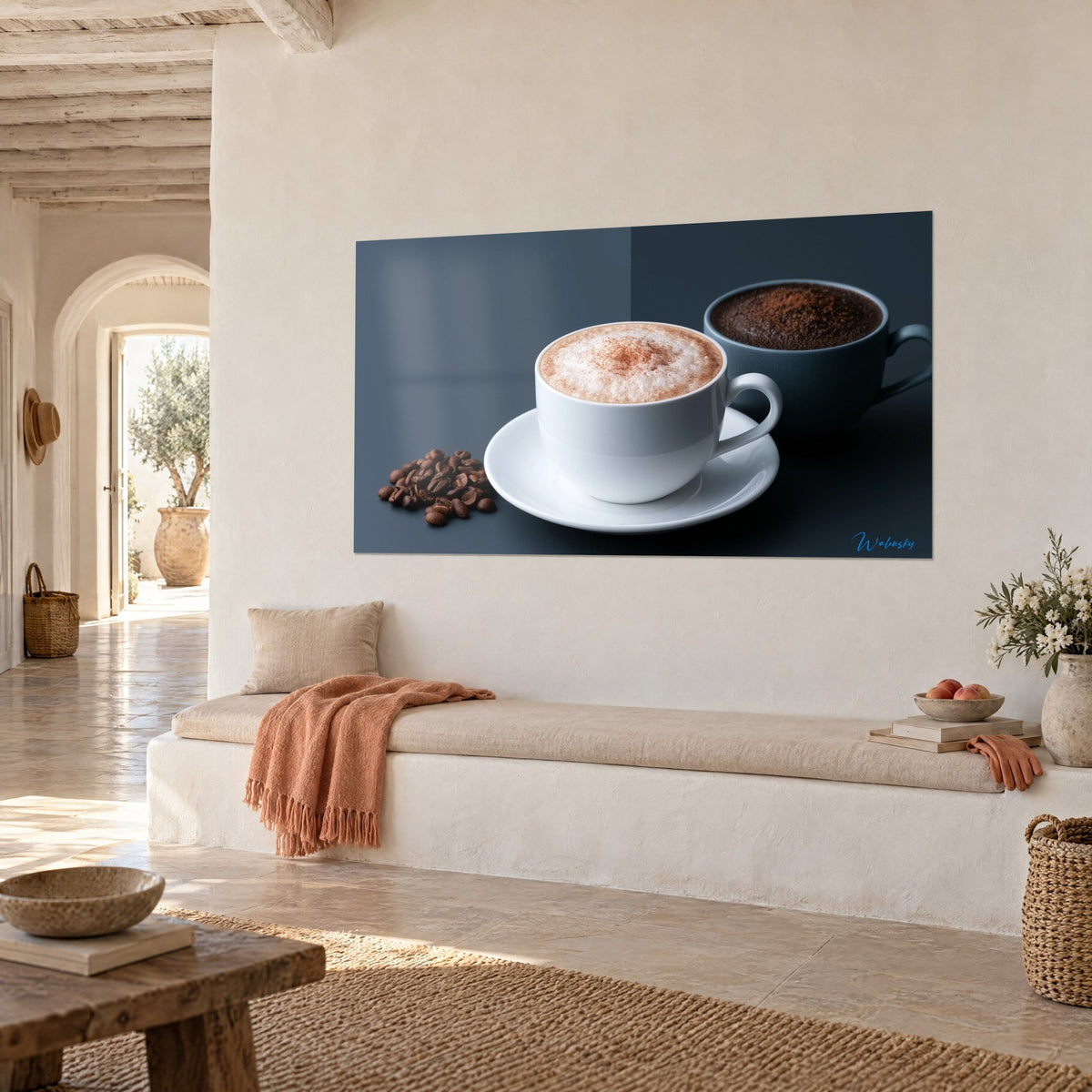 Cuadro taza de porcelana blanca y granos de café marrones sobre fondo gris azulado, colgado en una pared de cal de una casa mediterránea