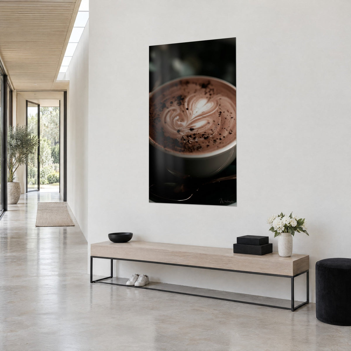 Tableau tasse de chocolat chaud nacrée, motif de cœur blanc et poudre brune, accroché en vue de trois-quarts dans un couloir clair