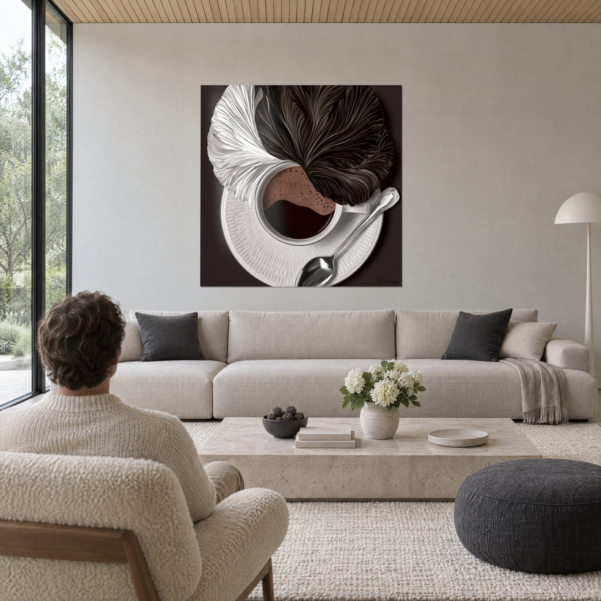 Tableau tasse de café fumant coiffée de plumes noires et blanches, fond brun, au-dessus d'un canapé dans un salon lumineux
