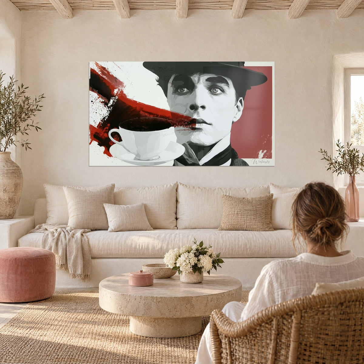 Gemälde Porträt mit schwarzem Hut und weißer Tasse, roter Spritzer auf rosa Hintergrund, über einem Sofa in einem hellen Wohnzimmer