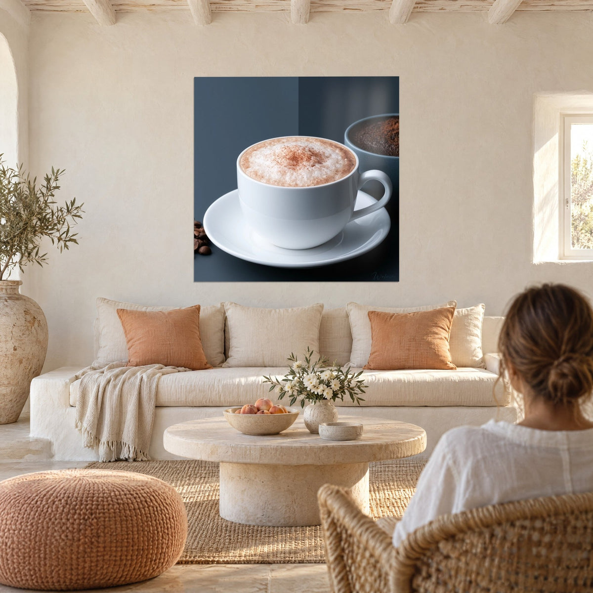 Tableau cappuccino à la mousse ambrée, tasse blanche sur fond bleu ardoise, au-dessus d'un canapé dans un salon lumineux