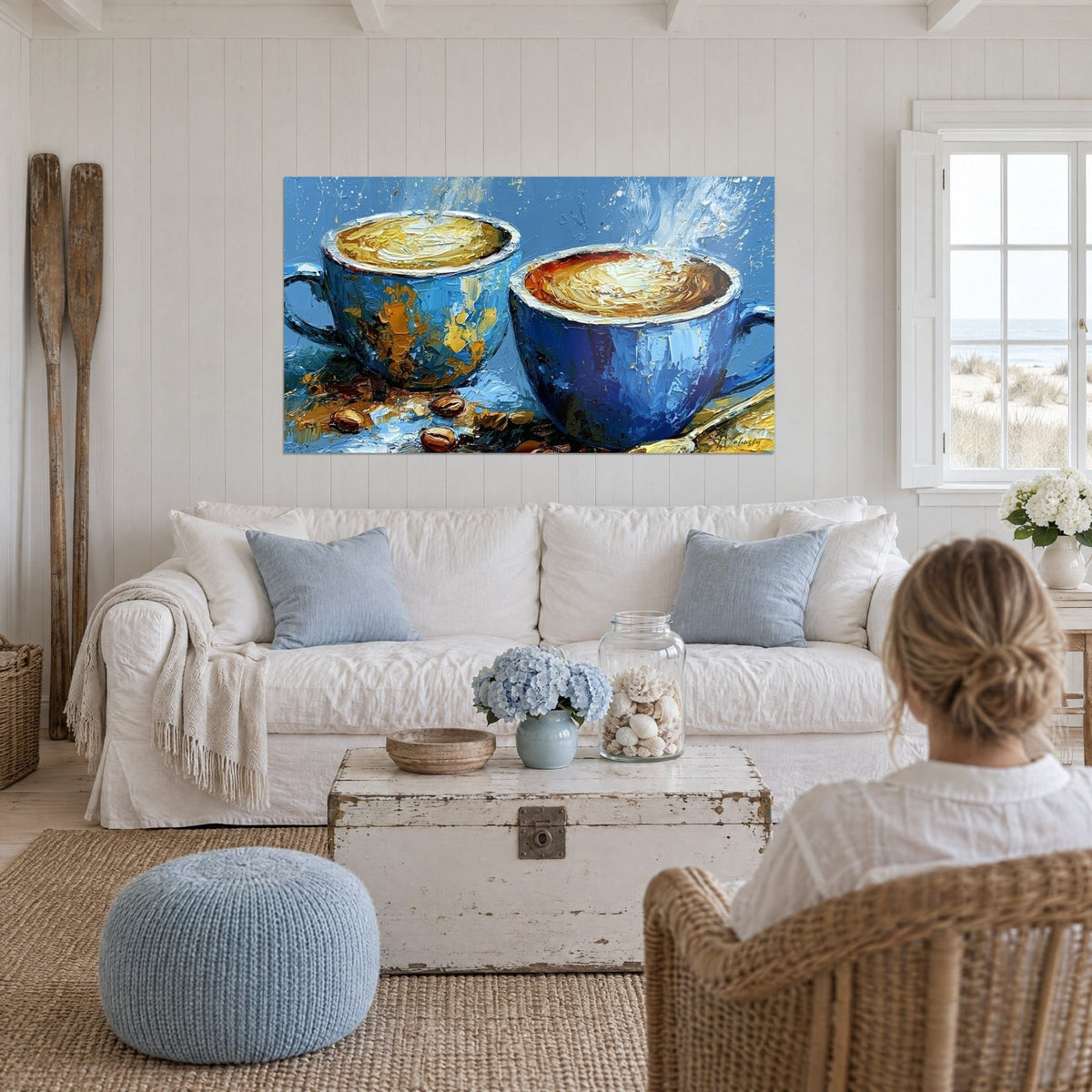 Tableau deux tasses bleu cobalt fumantes, mousse dorée en empâtements, grains de café, au-dessus d'un canapé dans un salon lumineux