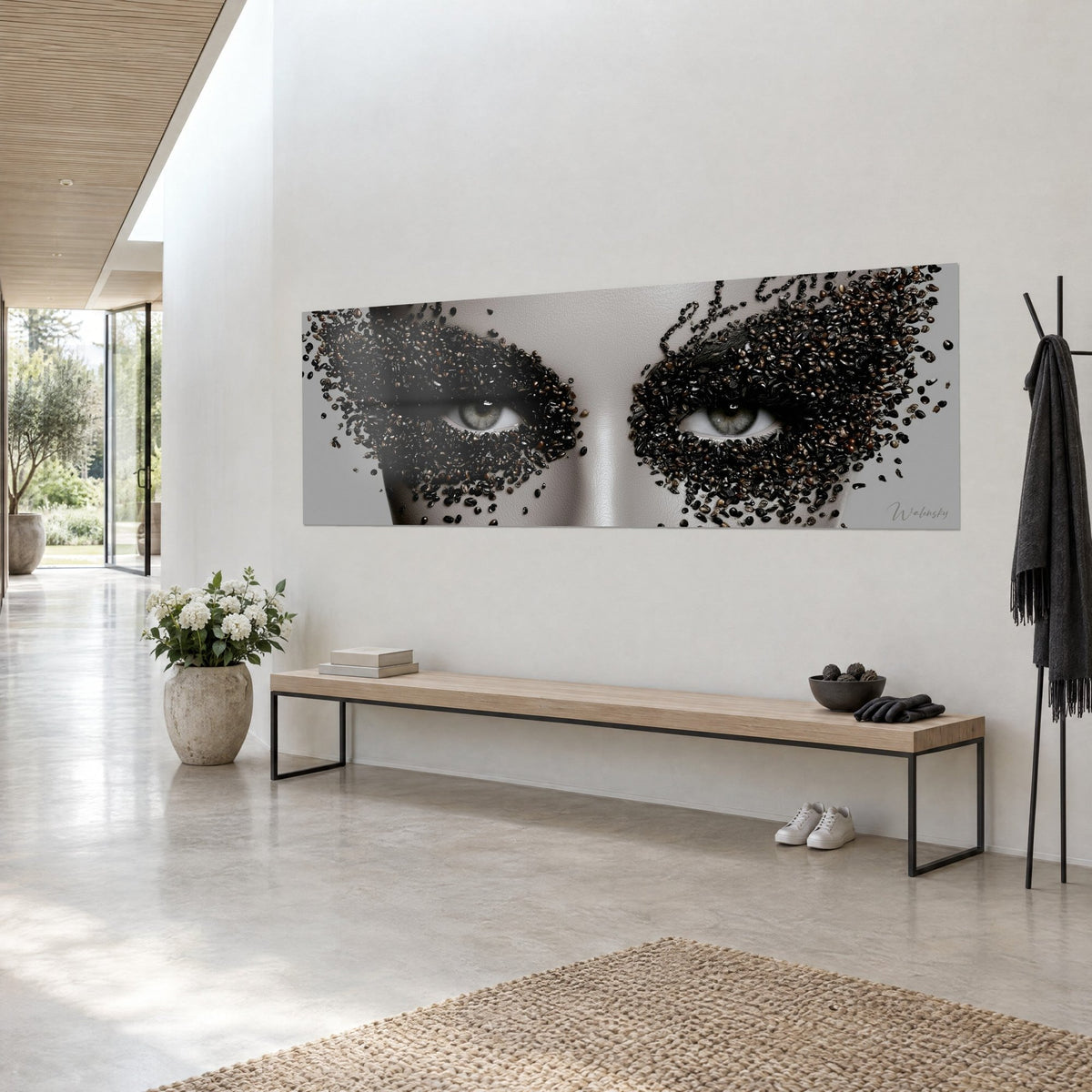 Tableau visage de porcelaine gris, yeux verts masqués d'une pluie de grains torréfiés ébène et caramel, banc en bois, hall clair