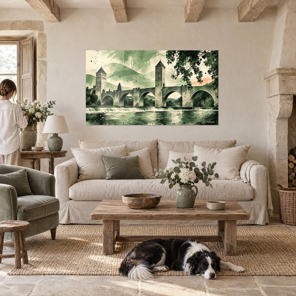 Wall art of Pont Valentré in sage green and cream tones, crenellated towers and arches over the water, above a sofa in a bright living room