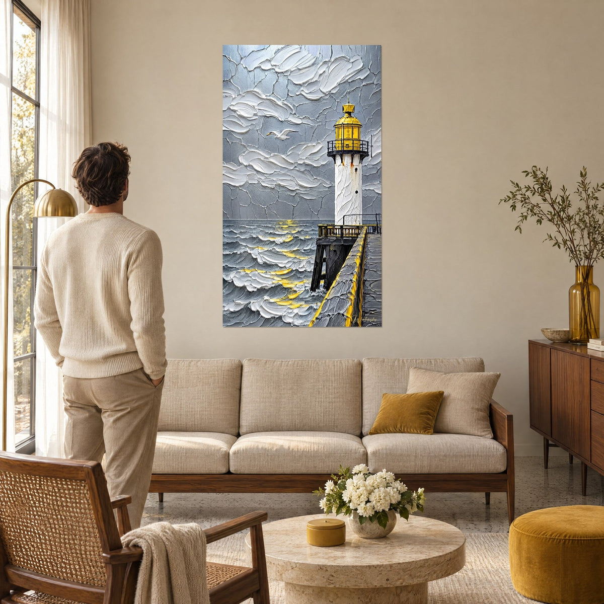 Gemälde Leuchtturm mit gelber Laterne vor weißem und grauem Teig-Himmel, goldene Wellen, Mann von hinten, über einem Sofa in einem hellen Wohnzimmer