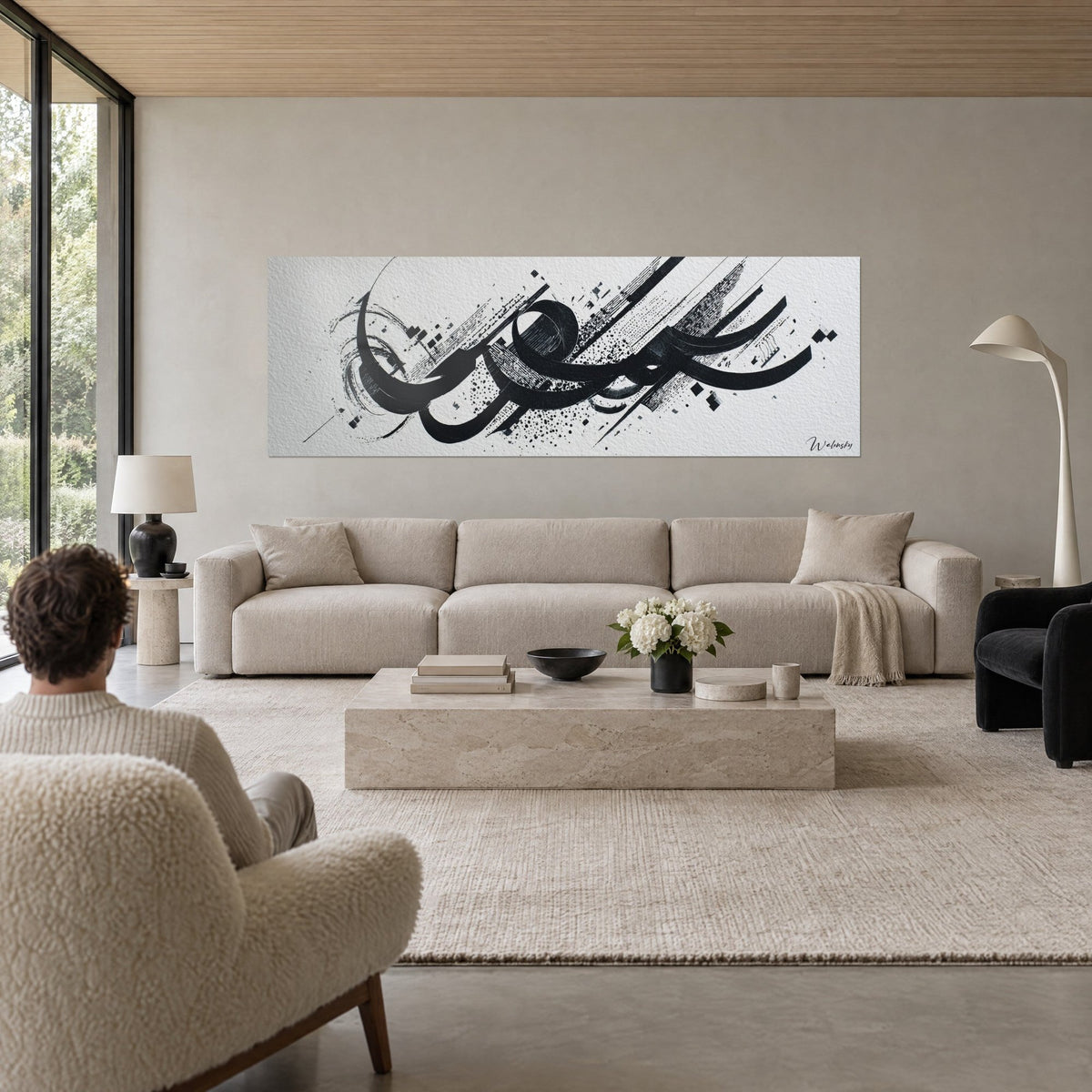 Gemälde mit schwarzer Kalligrafie in großen Tintenschwüngen auf weißem Papier, feine Spritzer, über einem Sofa in einem hellen Wohnzimmer