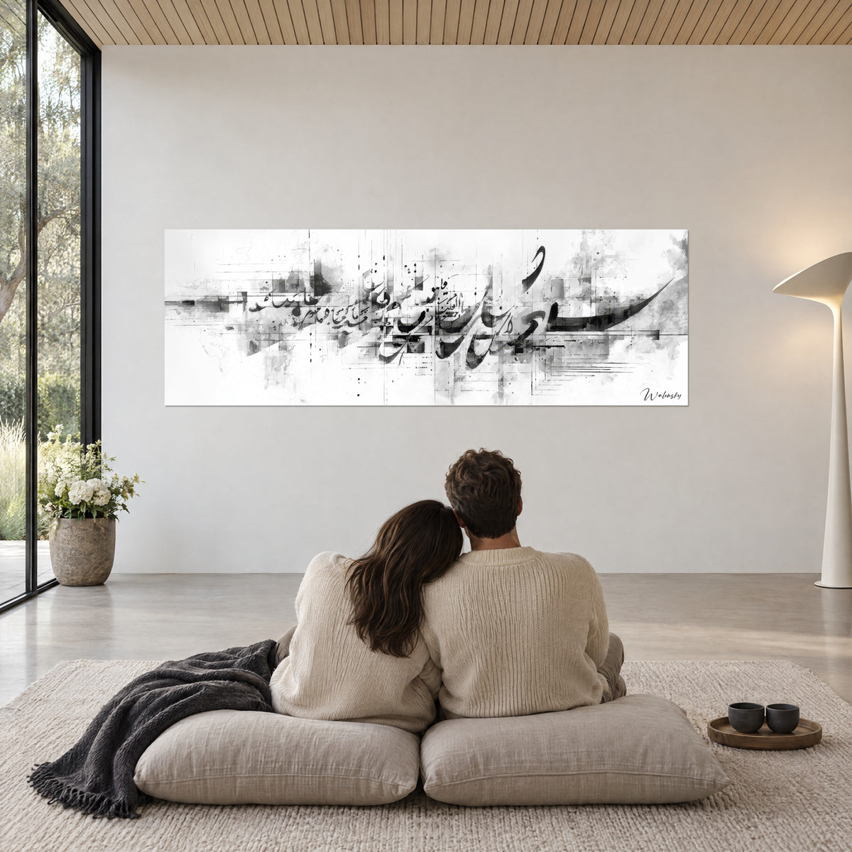 Wall art urban fusion in black Arabic calligraphy, grey mists and white background, an embracing couple seen from behind on beige poufs