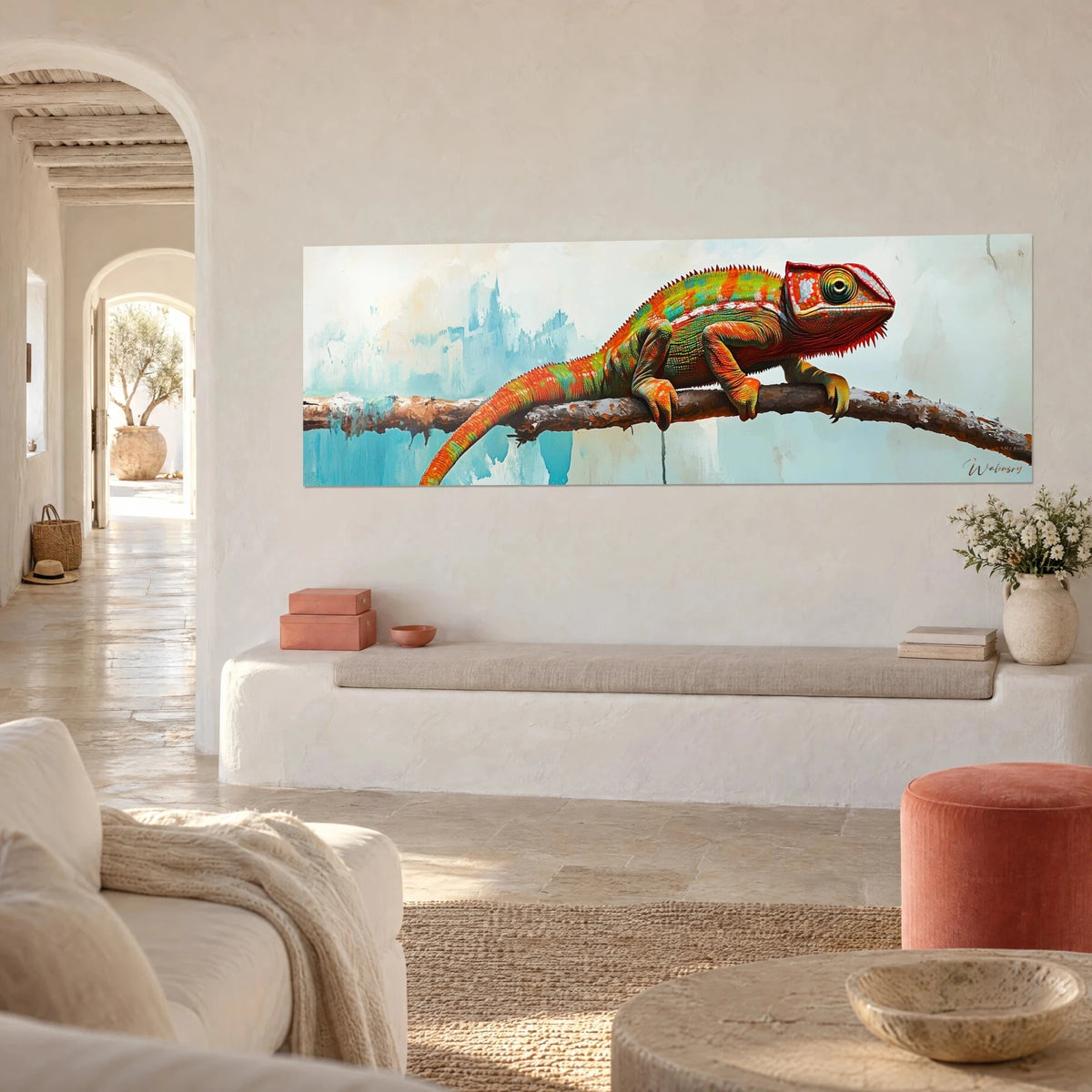 Tableau reptile aux écailles rouille et vertes agrippé à une branche brune, fond bleu pâle, mur blanc d'une maison méditerranéenne