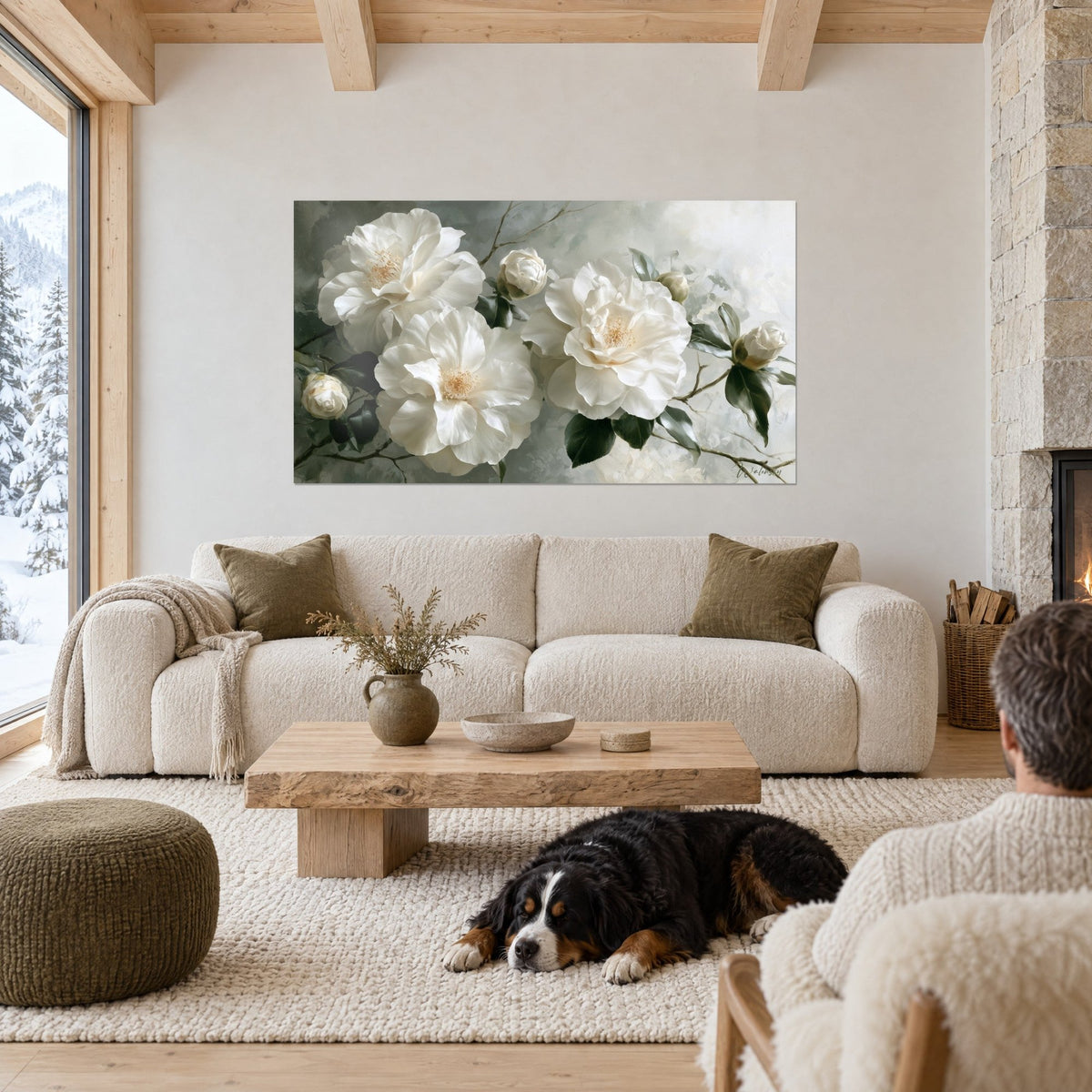 Tableau camélias blancs aux étamines dorées sur fond gris sauge, chien noir couché, au-dessus d'un canapé dans un salon lumineux