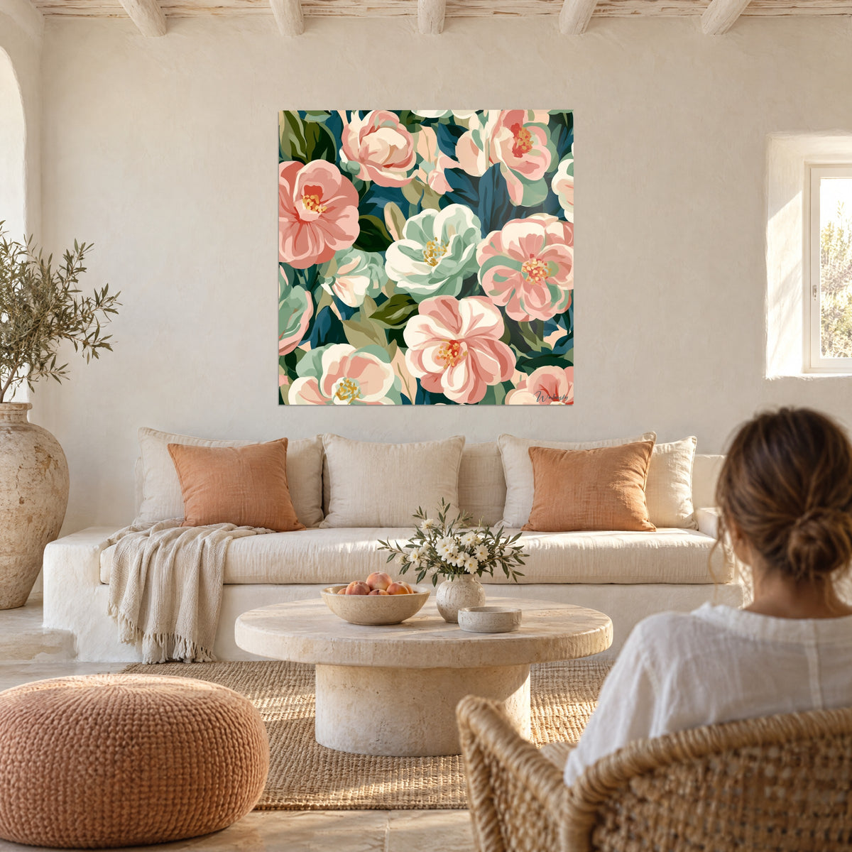 Tableau bouquet dense de camélias rose poudré et menthe sur feuillage bleu canard, au-dessus d'un canapé dans un salon lumineux