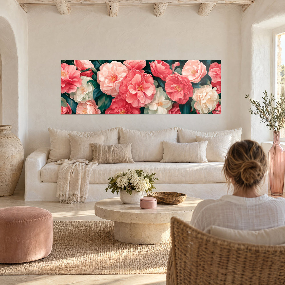 Tableau camélias rose corail et blanc crème, pétales superposés sur feuillage vert sombre, au-dessus d'un canapé dans un salon lumineux