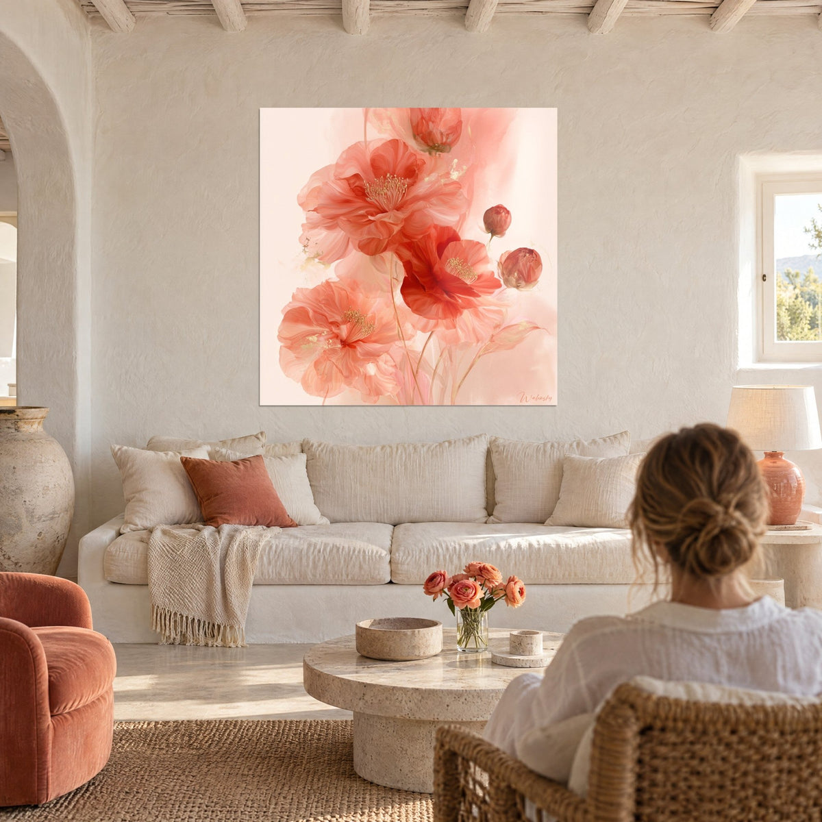 Tableau camélias corail aux étamines dorées, pétales rouges translucides sur fond pêche, au-dessus d'un canapé dans un salon lumineux