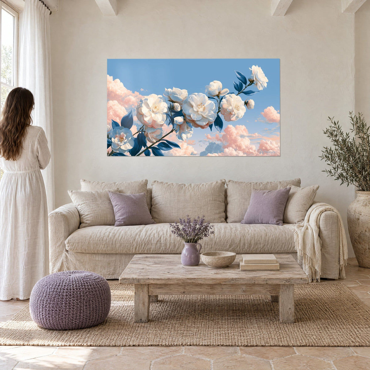 Tableau camélias ivoire aux feuilles bleu marine sur ciel azur, nuages rose pâle, au-dessus d'un canapé dans un salon lumineux
