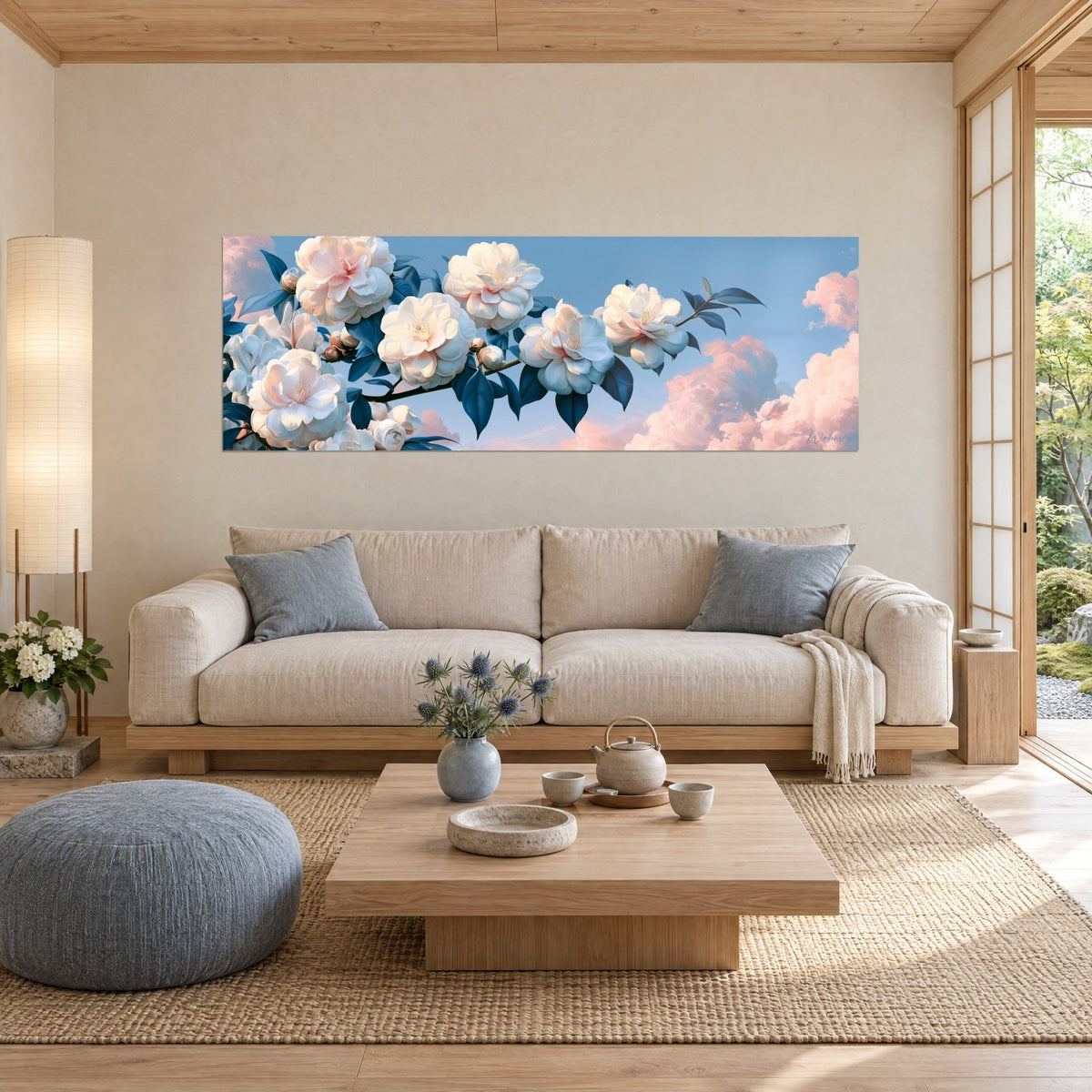 Tableau camélias ivoire sur branche sombre, feuilles bleu nuit et nuages rose pâle, au-dessus d'un canapé dans un salon lumineux
