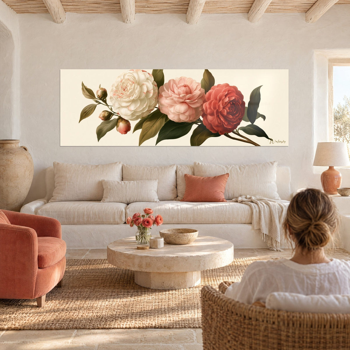 Tableau trio de camélias crème, rose poudré et corail sur fond ivoire, feuilles vert olive, au-dessus d'un canapé dans un salon lumineux