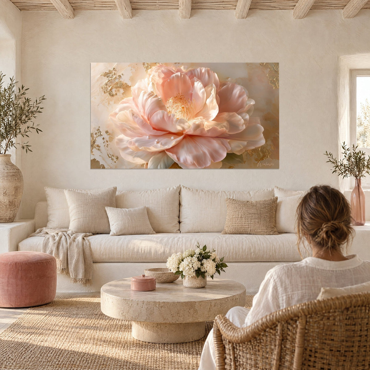 Tableau camélia rose pâle aux pétales satinés, éclats de feuille d'or et perles blanches, au-dessus d'un canapé dans un salon lumineux