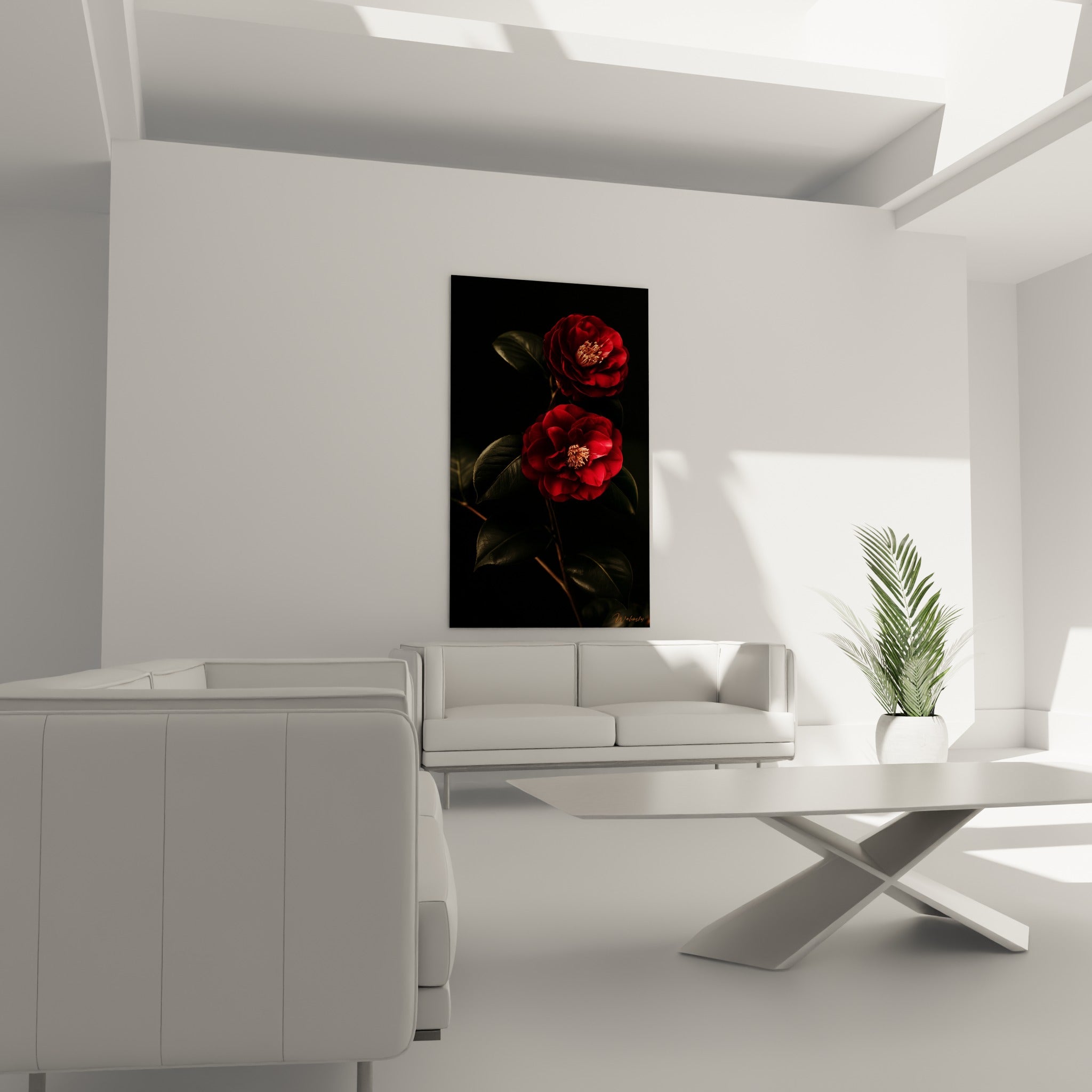 Pétales de camélia rouge intense et feuillage anthracite installés au-dessus d'un canapé dans un salon lumineux