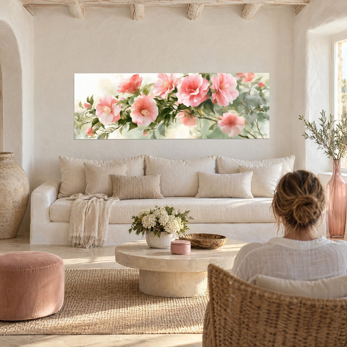 Tableau camélias roses épanouis sur branche feuillue, fond vert d'eau, au-dessus d'un canapé dans un salon lumineux