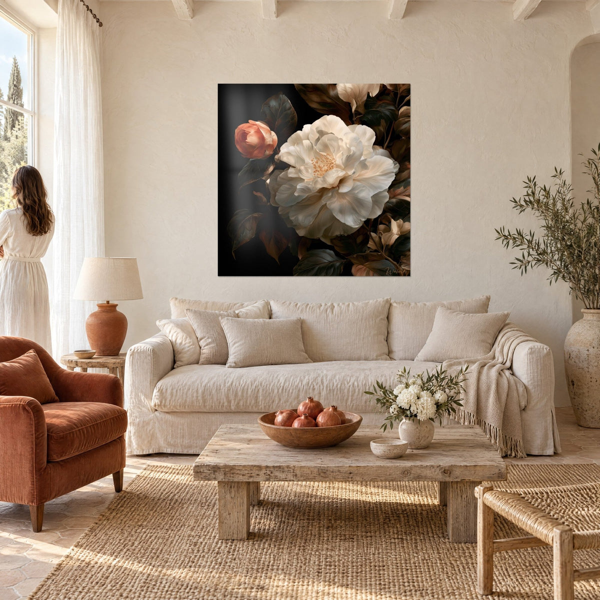 Cuadro camelia blanca de pétalos nacarados junto a un capullo coral, fondo negro, encima de un sofá en un salón luminoso