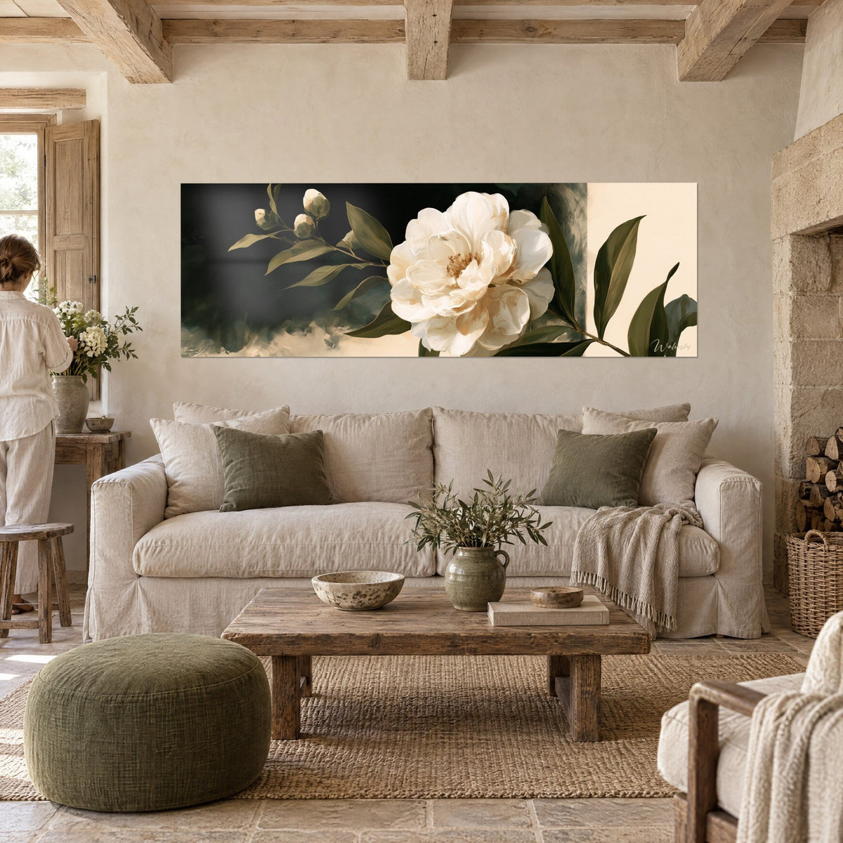 Wall art Ivory camellia in full bloom on black background, olive green leaves, two closed buds, above a sofa in a bright living room