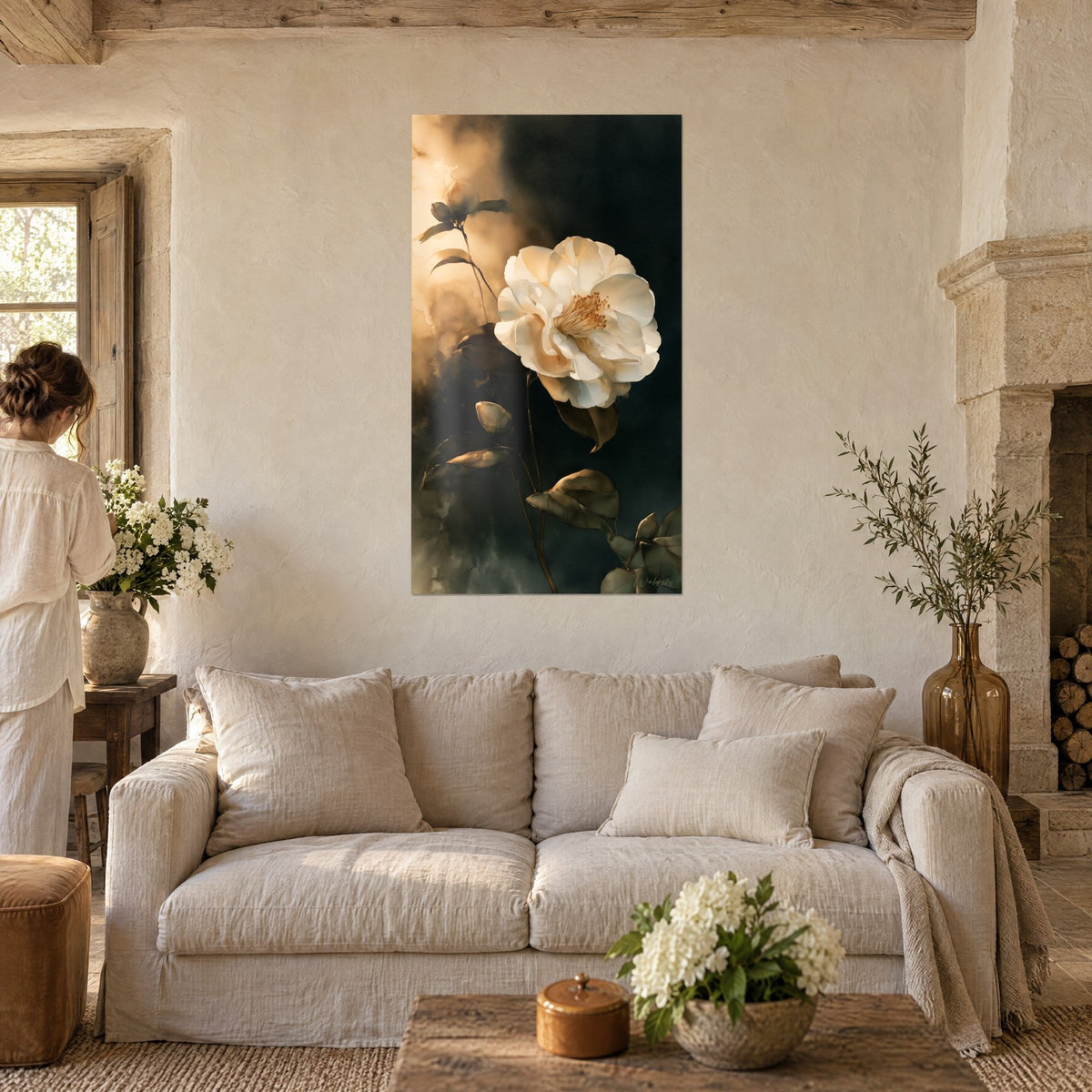 Tableau camélia blanc aux pétales ivoire sur fond ardoise et ocre doré, visiteur de dos, au-dessus d'un canapé dans un salon lumineux