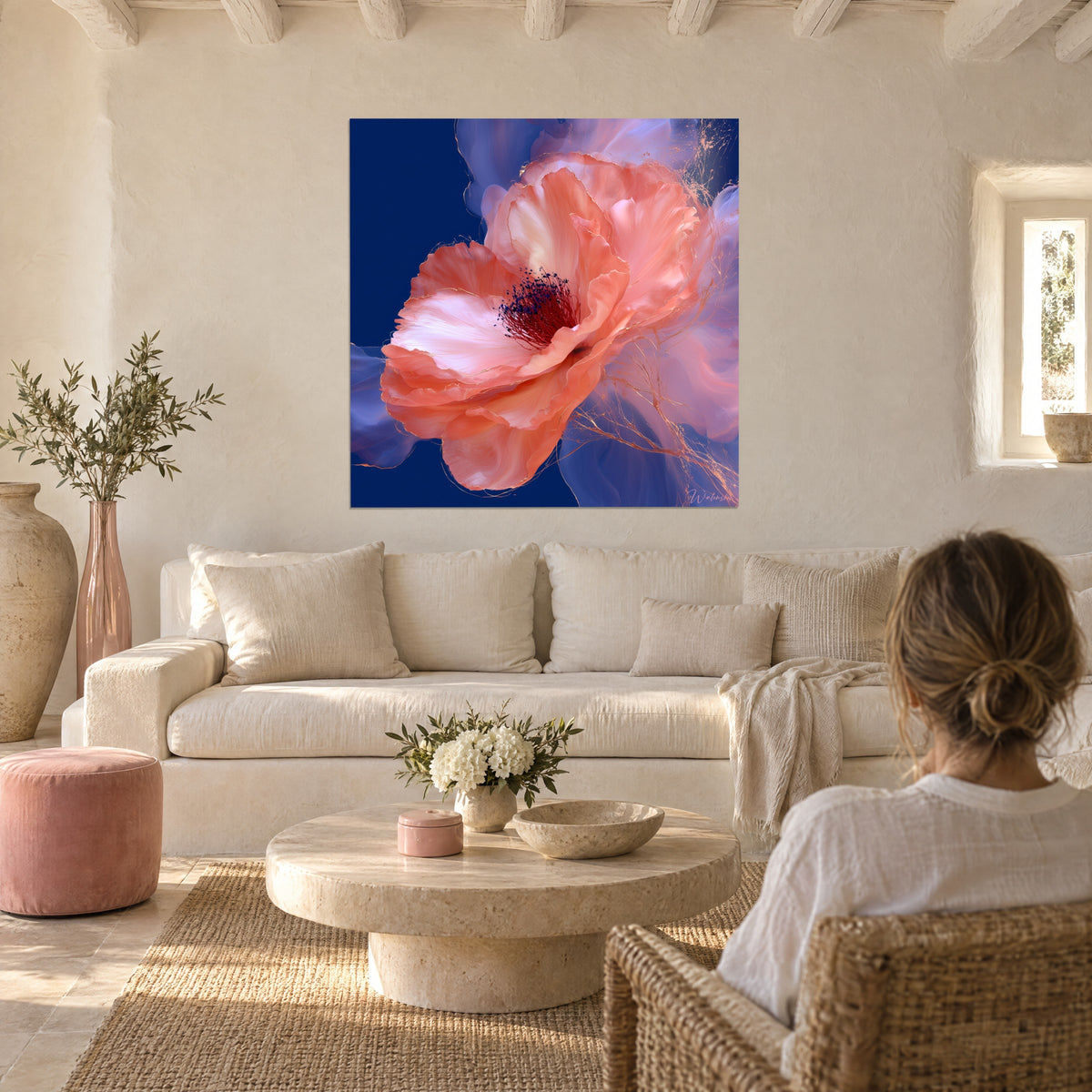 Wall art camellia flower in coral with burgundy stamens on navy blue background, hung above a sofa in a bright living room